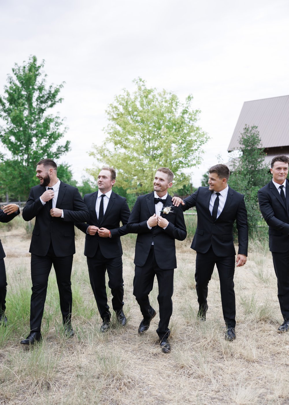  At Quiet Meadow Farms in Mapleton a group of groomsmen wearing black all laugh together by Savanna Richardson Photography. groomsmen style #SavannaRichardsonPhotography #SavannaRichardsonWeddings #QuietMeadowFarms #MapletonUTweddingphotographers 