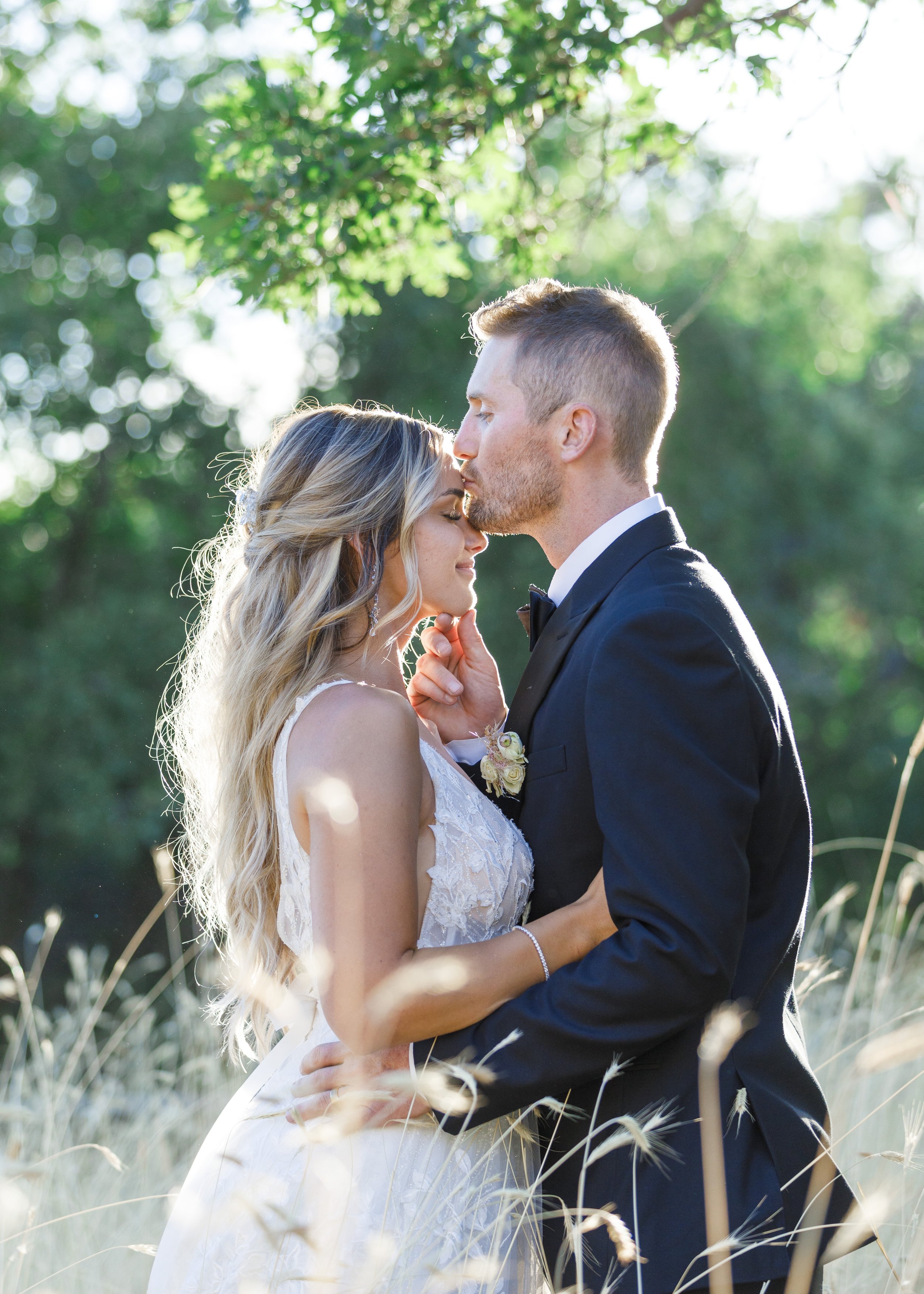  Among yellow grass, a groom kisses the top of his bride's head captured in Mapleton by Savanna Richardson Photography. country wedding pic #SavannaRichardsonPhotography #SavannaRichardsonWeddings #QuietMeadowFarms #MapletonUTweddingphotographers 