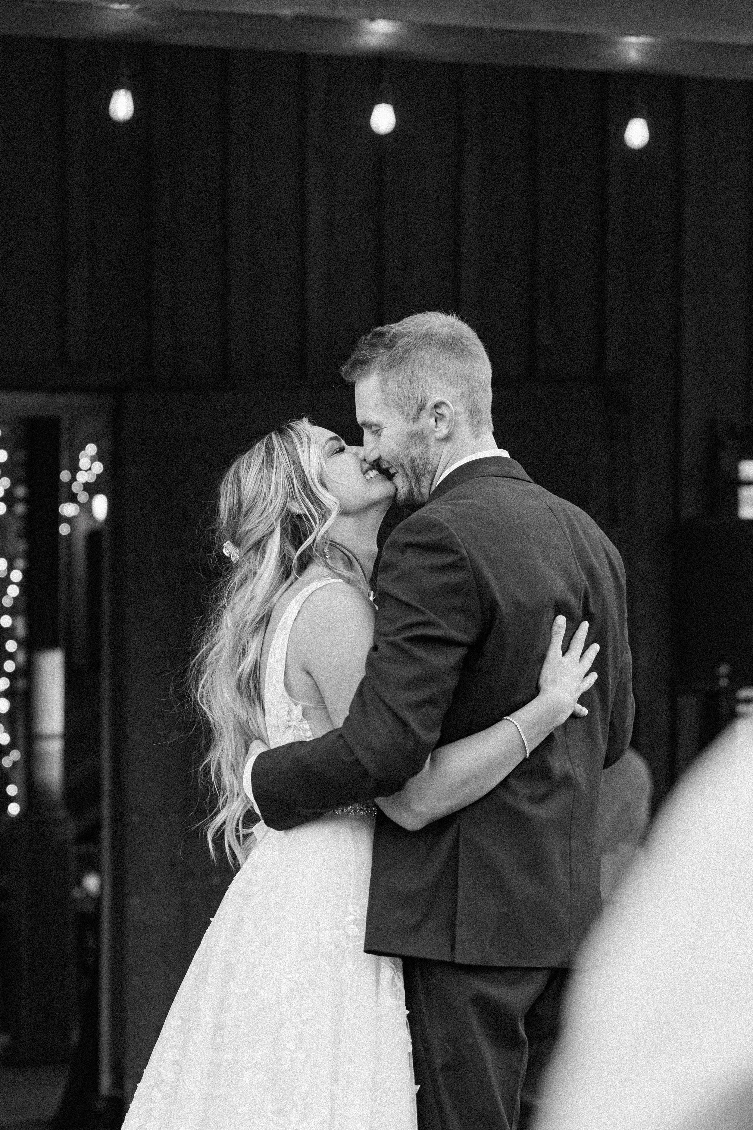  Savanna Richardson Photography captures a bride and groom kissing in a barn on their wedding day. black and white bridal portraits Utah #SavannaRichardsonPhotography #SavannaRichardsonWeddings #QuietMeadowFarms #MapletonUTweddingphotographers 