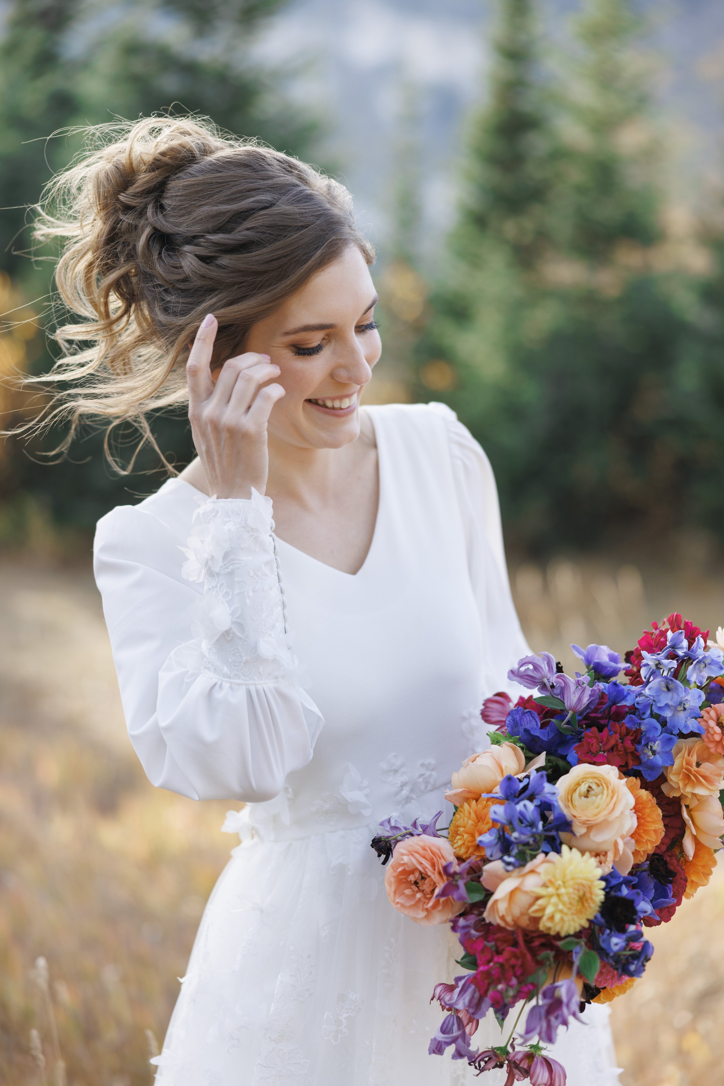  A bride smiles with her fall bouquet in the cottonwood Canyon by Savanna Richardson Photography. bridal candid portraits #SavannaRichardsonPhotography #SavannaRichardsonFormals #CottonwoodCanyon #WeddingFormals #SLCWedding #fallwed 