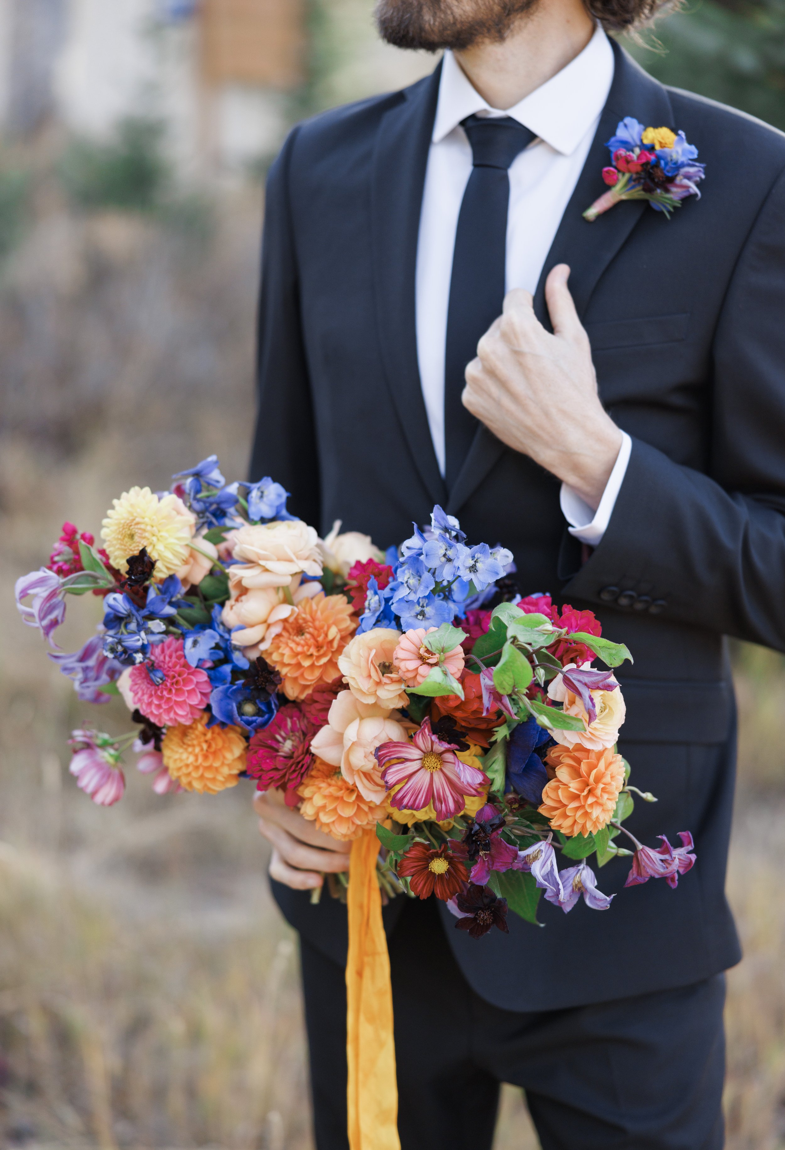  Groom holds the bride's colorful bouquet captured by Savanna Richardson Photography during a formal photoshoot. Utah photographers high end #SavannaRichardsonPhotography #SavannaRichardsonFormals #CottonwoodCanyon #WeddingFormals #SLCWedding #fallwe