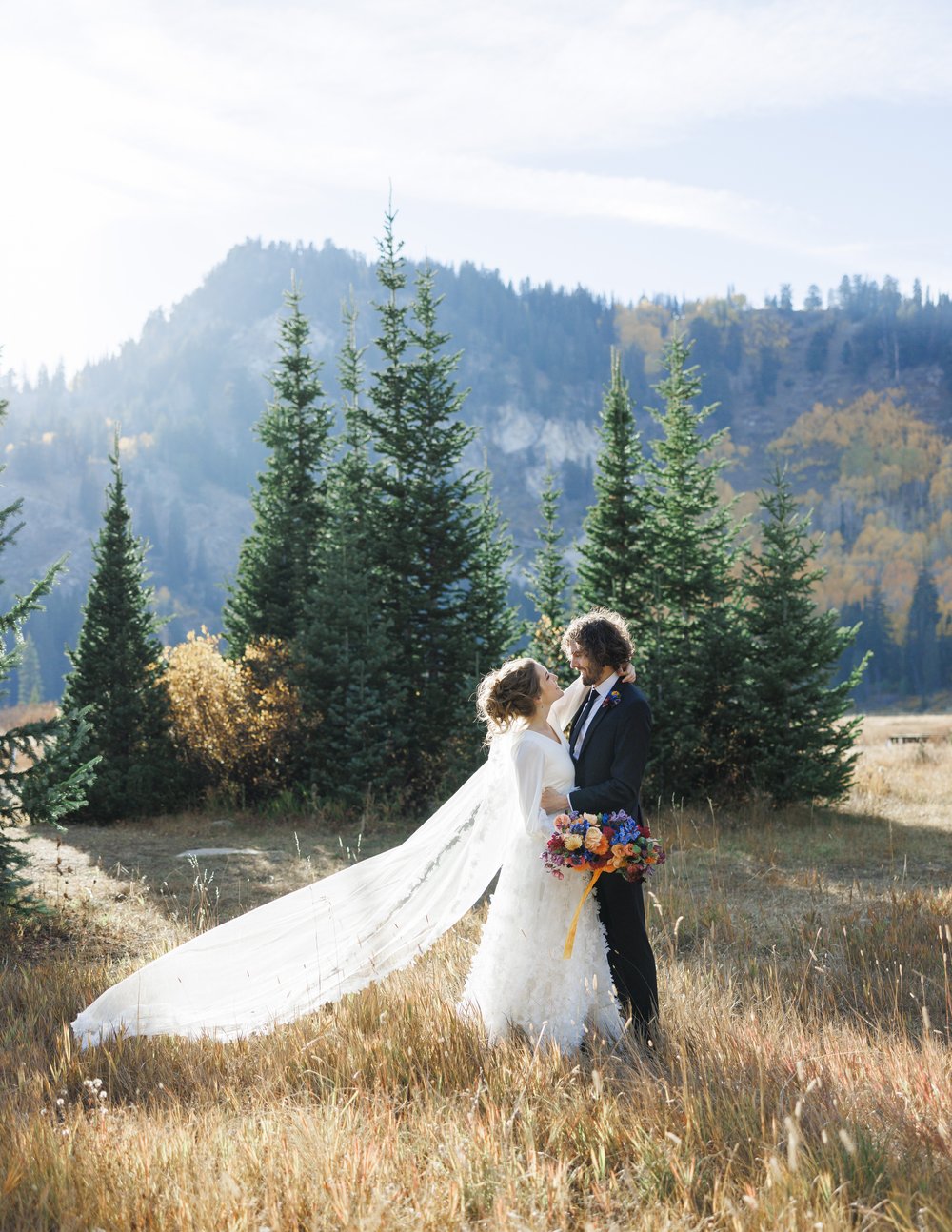  Savanna Richardson Photography captures a timeless wedding portrait of the bride in groom in the Utah mountains. mountain bridals sunburst #SavannaRichardsonPhotography #SavannaRichardsonFormals #CottonwoodCanyon #WeddingFormals #SLCWedding #fallwed