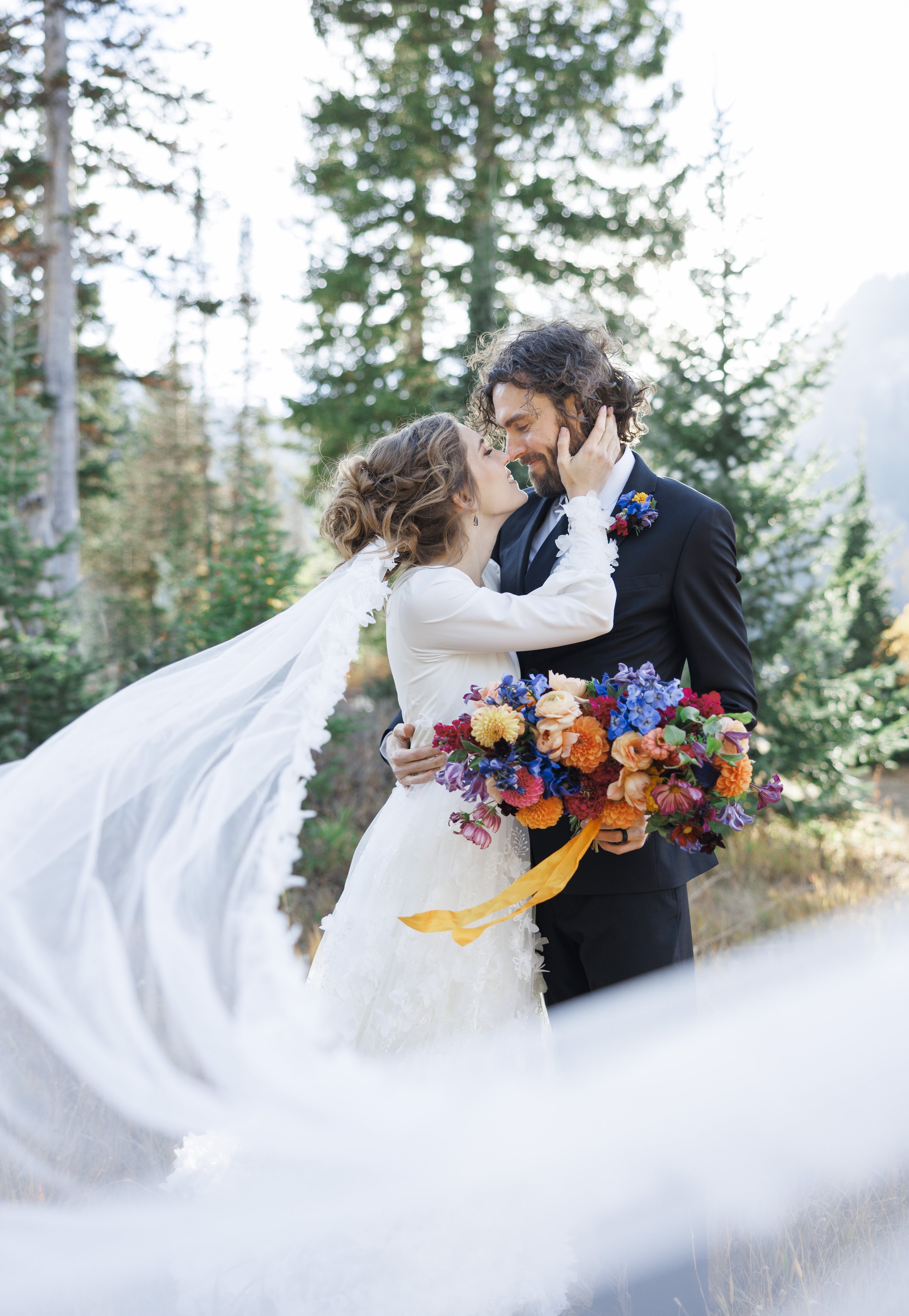  Savanna Richardson Photography captures the bridal veil blowing in the wind as the wedding duo kiss. veil bridal portraits kissing bridals #SavannaRichardsonPhotography #SavannaRichardsonFormals #CottonwoodCanyon #WeddingFormals #SLCWedding #fallwed