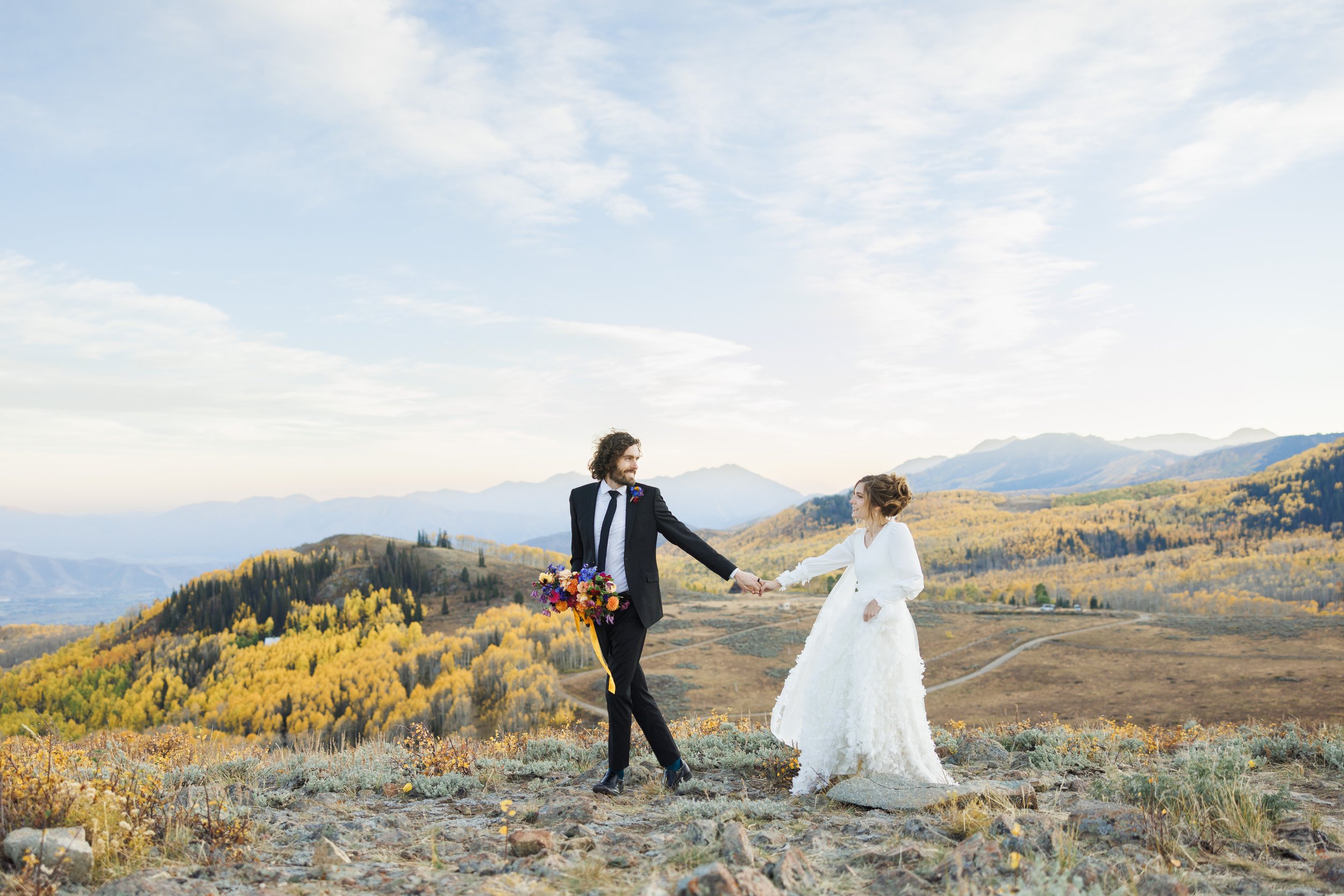  In the Cottonwood Canyon, the bride and groom walk along the mountain top with yellow trees behind them by Savanna Richardson Photography.  #SavannaRichardsonPhotography #SavannaRichardsonFormals #CottonwoodCanyon #WeddingFormals #SLCWedding #fallwe