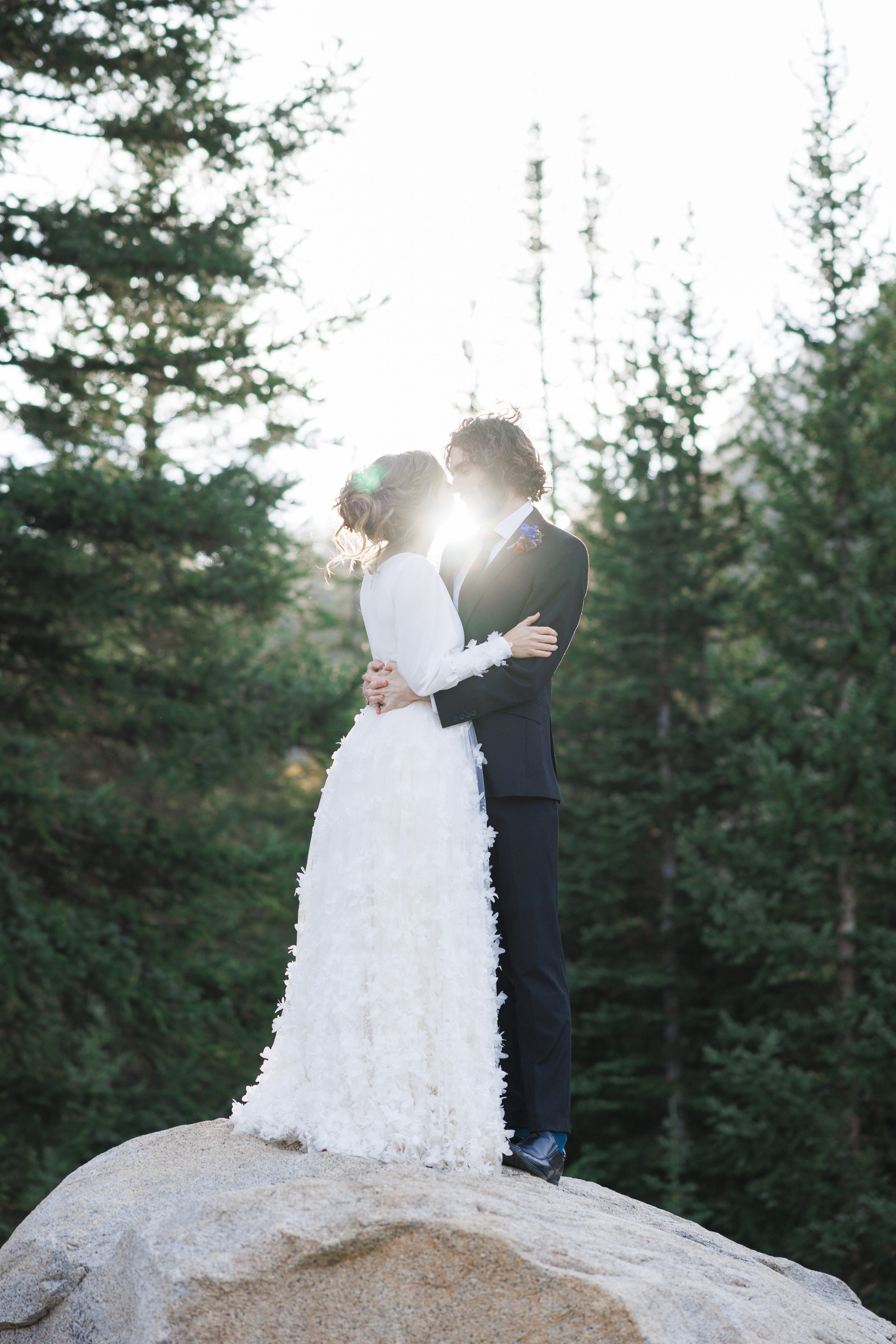  Standing on a rock the bride and groom kiss with the sun between them by Savanna Richardson Photography. pine tree bridals #SavannaRichardsonPhotography #SavannaRichardsonFormals #CottonwoodCanyon #WeddingFormals #SLCWedding #fallwed 