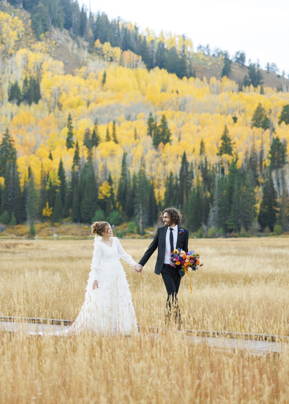  The groom and bride hold hands on a dirt path with fall leaves behind them captured by Savanna Richardson Photography. wed photo locations #SavannaRichardsonPhotography #SavannaRichardsonFormals #CottonwoodCanyon #WeddingFormals #SLCWedding #fallwed