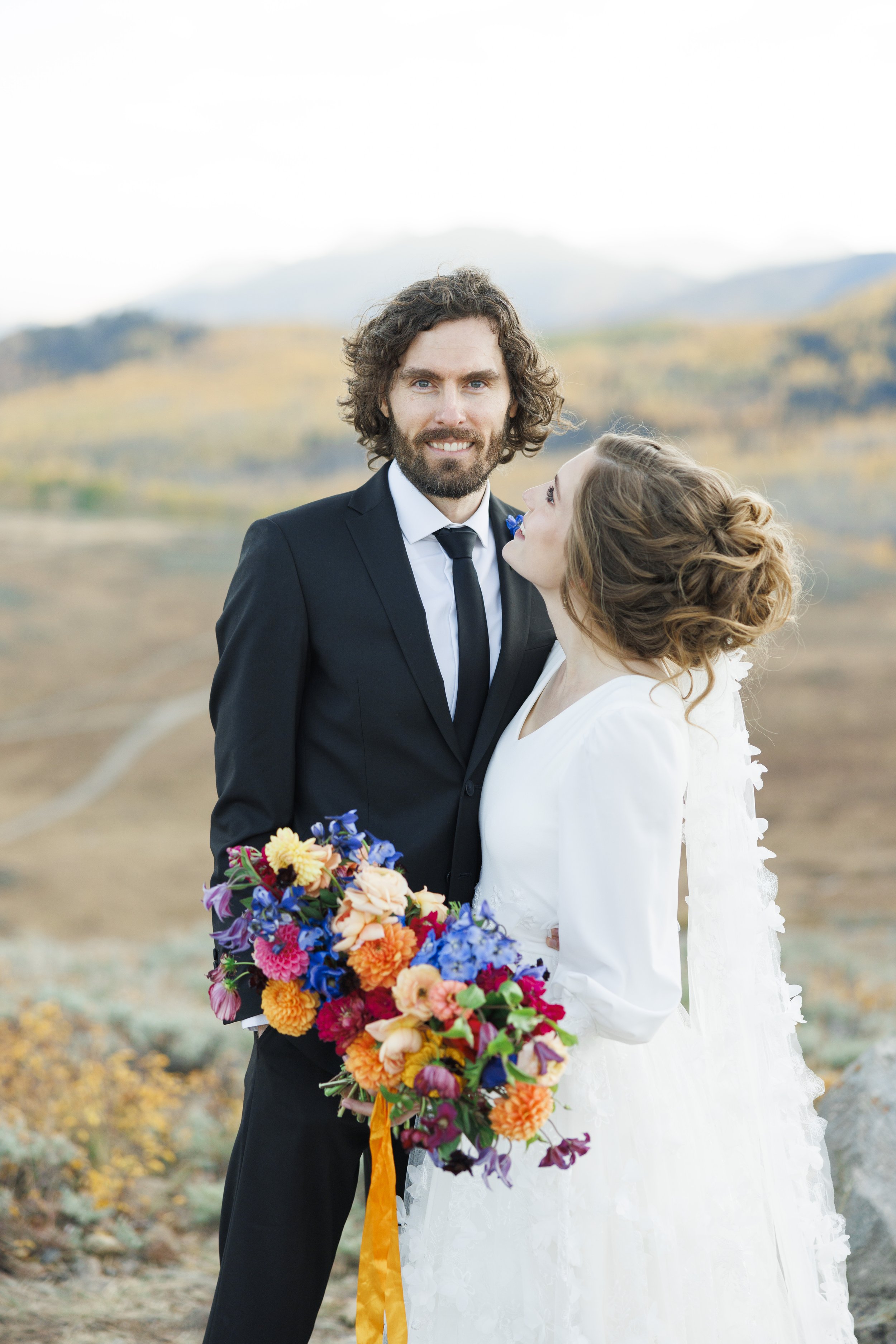  A portrait of a groom in a black suit with his bride holding onto him by Savanna Richardson Photography. classy wedding formals #SavannaRichardsonPhotography #SavannaRichardsonFormals #CottonwoodCanyon #WeddingFormals #SLCWedding #fallwed 