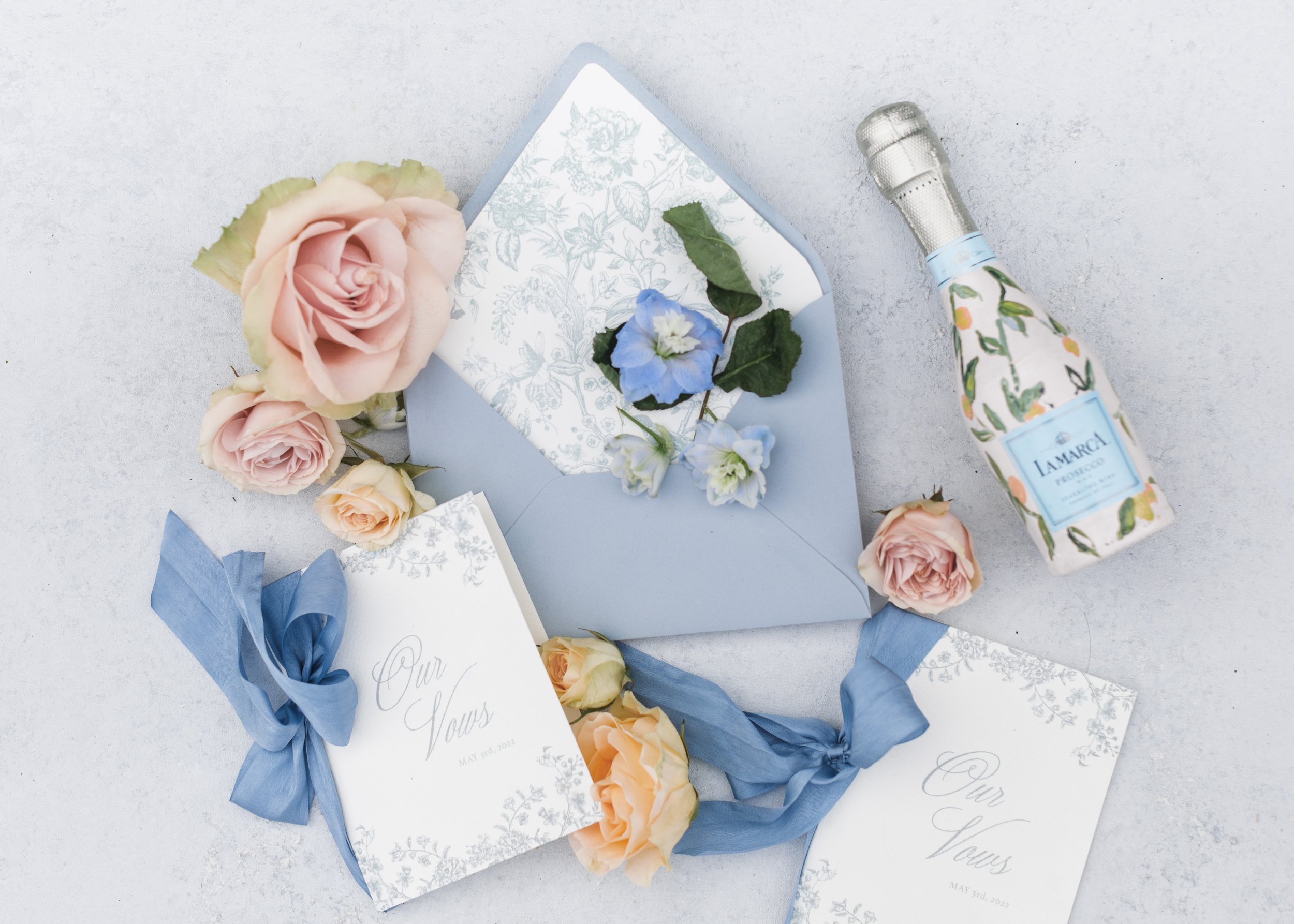  A flat lay of a wedding announcement with florals and a champagne bottle by Savanna Richardson Photography. spring flat lay #SavannaRichardsonPhotography #SavannaRichardsonWeddings #bridals #formals #bouquets #Utahweddingphotographers #Wedding 