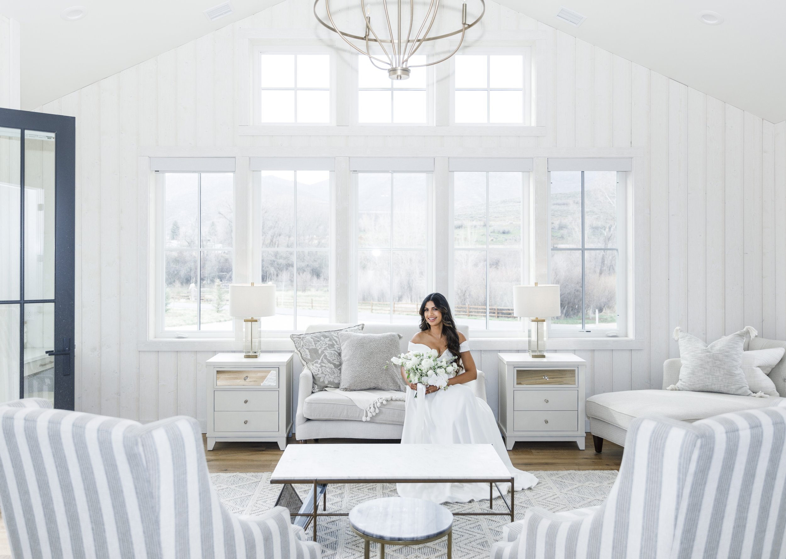 A bride sits in an all-white bridal room on her wedding day captured by Savanna Richardson Photography. high-end wedding photographer #SavannaRichardsonPhotography #SavannaRichardsonWeddings #bridals #formals #bouquets #Utahweddingphotographers 