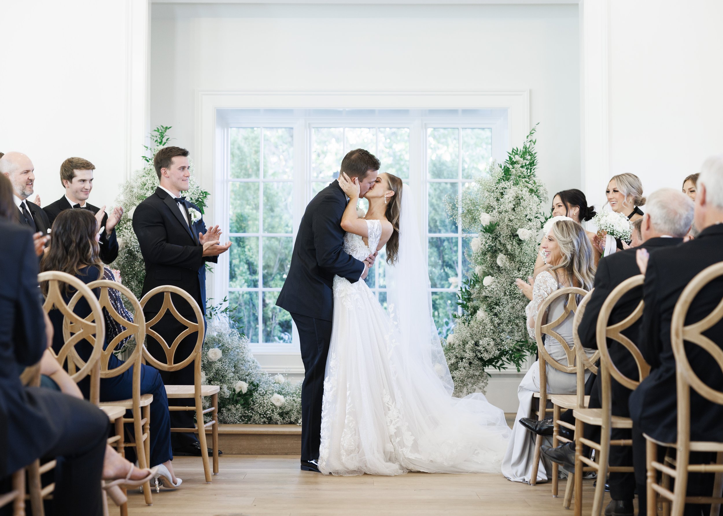  Savanna Richardson Photography captures a bride and groom kissing at the end of the altar on their wedding day. indoor wedding #SavannaRichardsonPhotography #SavannaRichardsonWeddings #bridals #formals #bouquets #Utahweddingphotographers #Wedding 