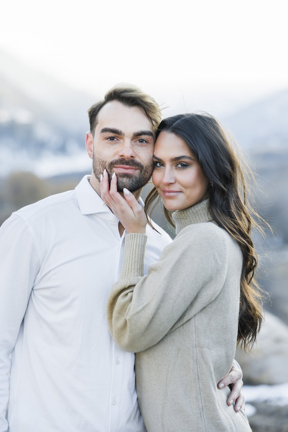  A woman and man snuggled together in the Utah mountains for a snowy proposal captured by Savanna Richardson Photography. clean portraits #SavannaRichardsonPhotography #Proposal #proposalphotography #ProProposalCompany #engaged #engagementphotography