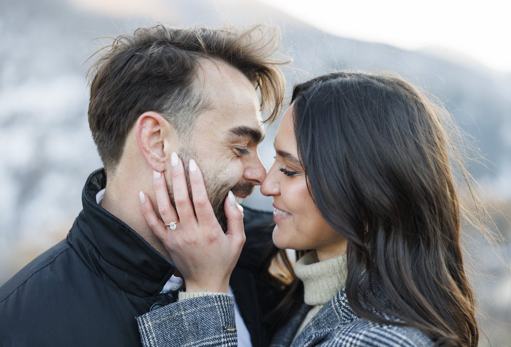  An engaged couple kiss with a woman holding a man's face showing off the wedding ring captured by Savanna Richardson Photography. ring #SavannaRichardsonPhotography #Proposal #proposalphotography #ProProposalCompany #engaged #engagementphotography 