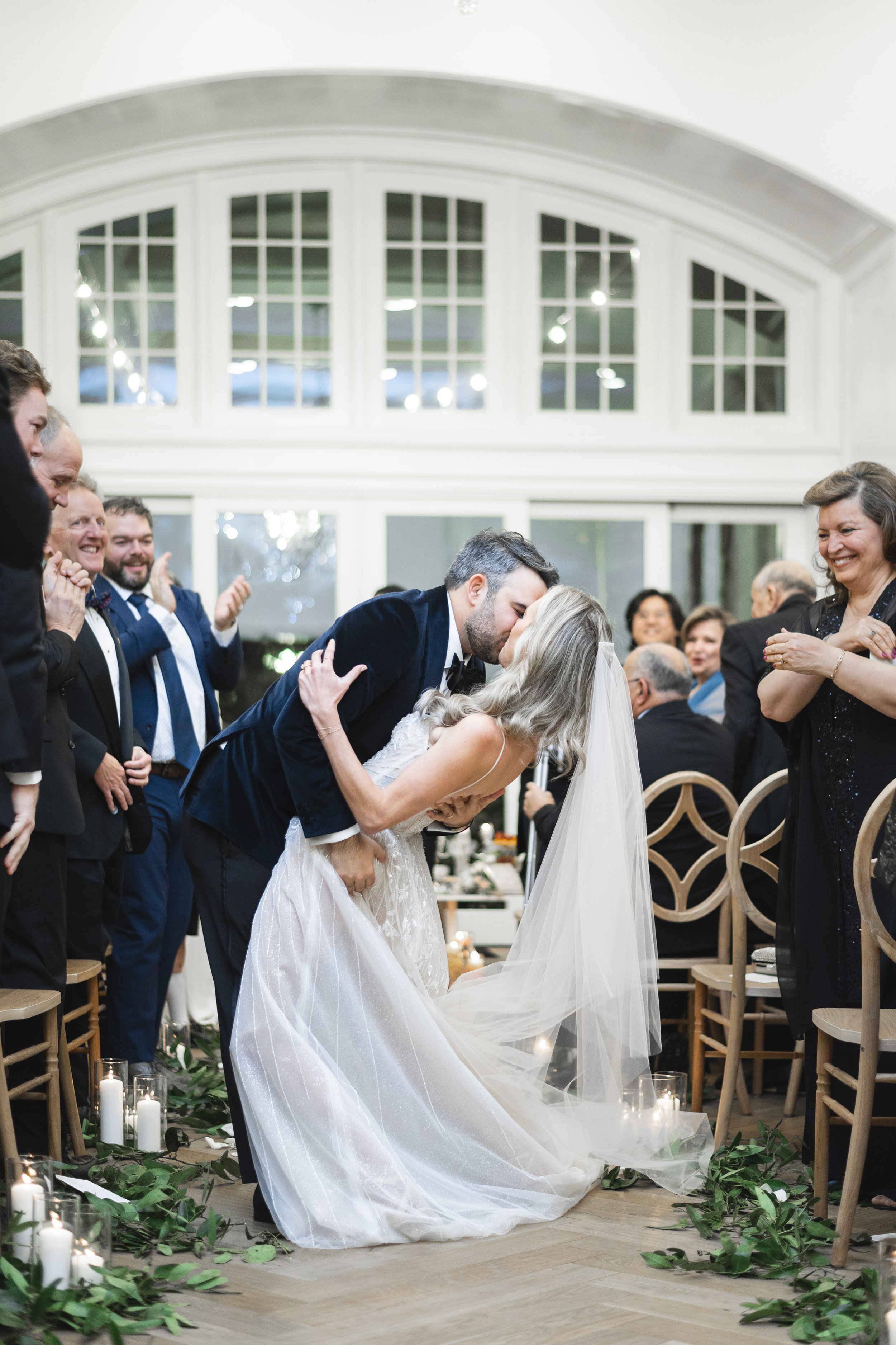  Savanna Richardson Photography captures a bride and groom kissing in the aisle at their wedding. she said I do #SavannaRichardsonPhotography #SavannaRichardsonWeddings #NYEwedding #magicalwedding #snowywedding #holidaywedding #married 