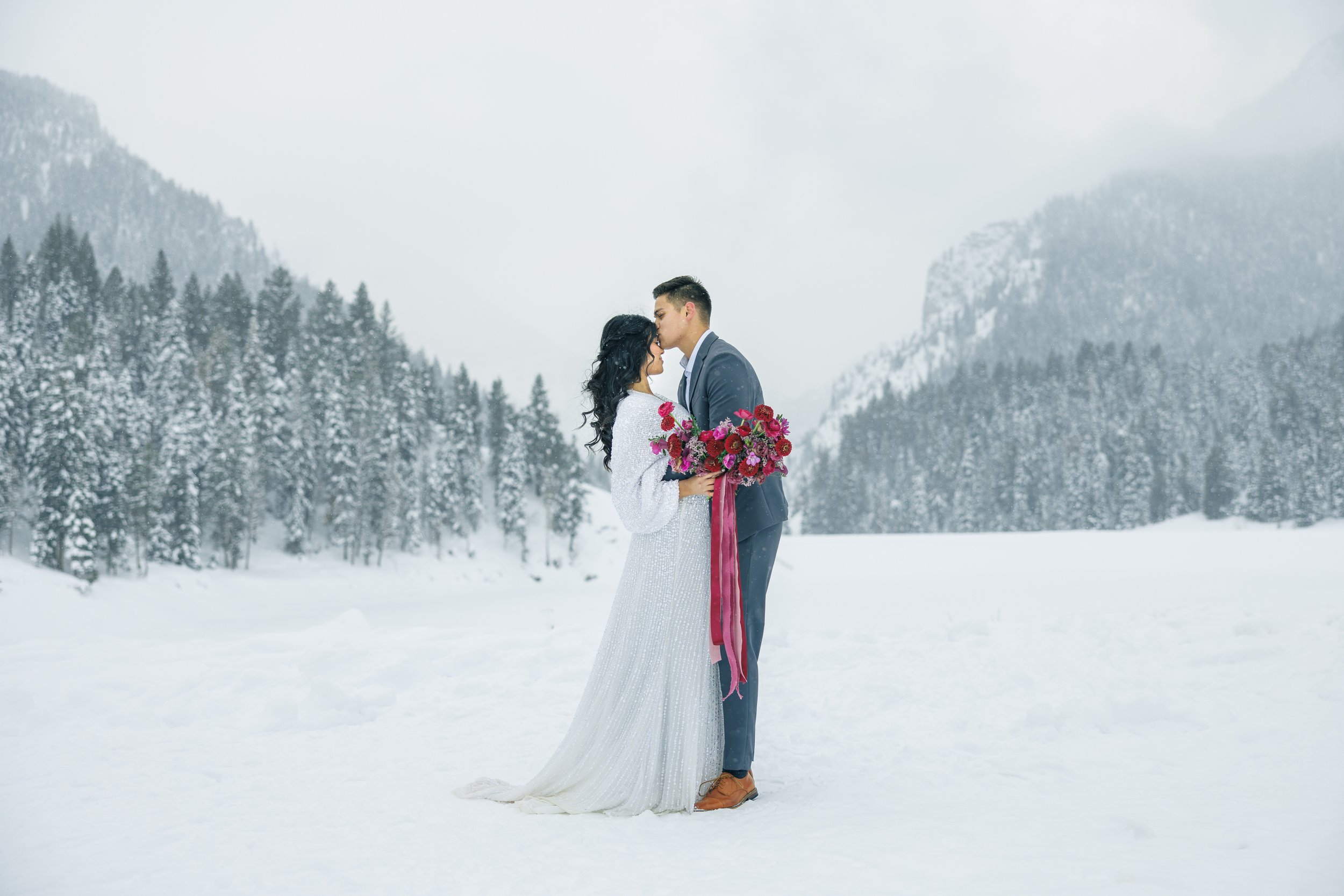  A groom kisses his bride on a snowy mountainside in Northern Utah by Savanna Richardson Photography. winter wedding #SavannaRichardsonPhotography #SavannaRichardsonBridals #WinterBridals #WinterWedding #TibbleForkBridals #UtahBridals #MountainBridal