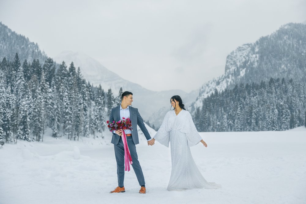  A bride and groom walk around a snowy mountainside during bridals with Savanna Richardson Photography. Tibble Fork #SavannaRichardsonPhotography #SavannaRichardsonBridals #WinterBridals #WinterWedding #TibbleForkBridals #UtahBridals #MountainBridals