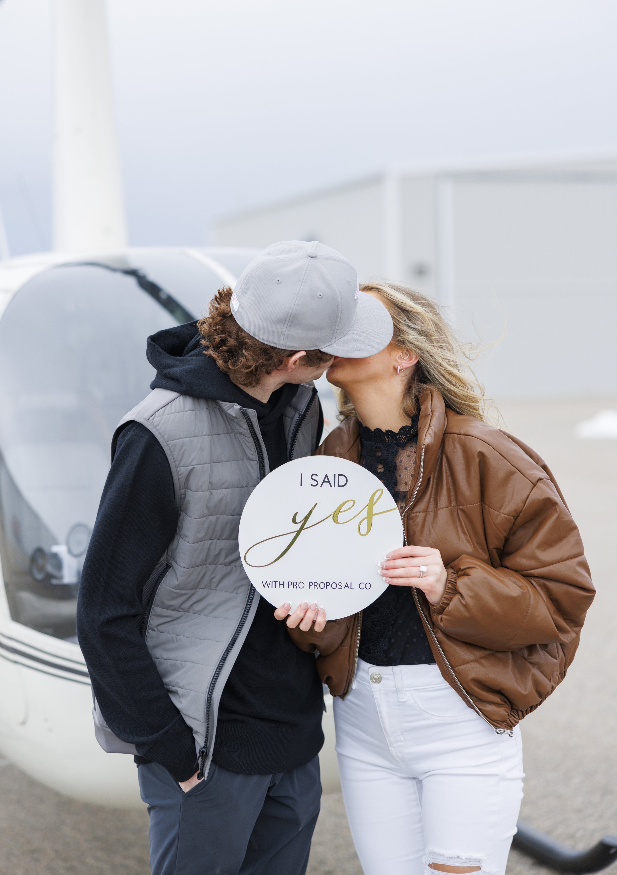  A newly engaged couple holds up a wooden sign with the words "She said Yes" on them by Savanna Richardson Photography. She said yes proposal photography she said yes signs #SavannaRichardsonPhotography #SavannaRichardsonEngagements #utahproposals #h
