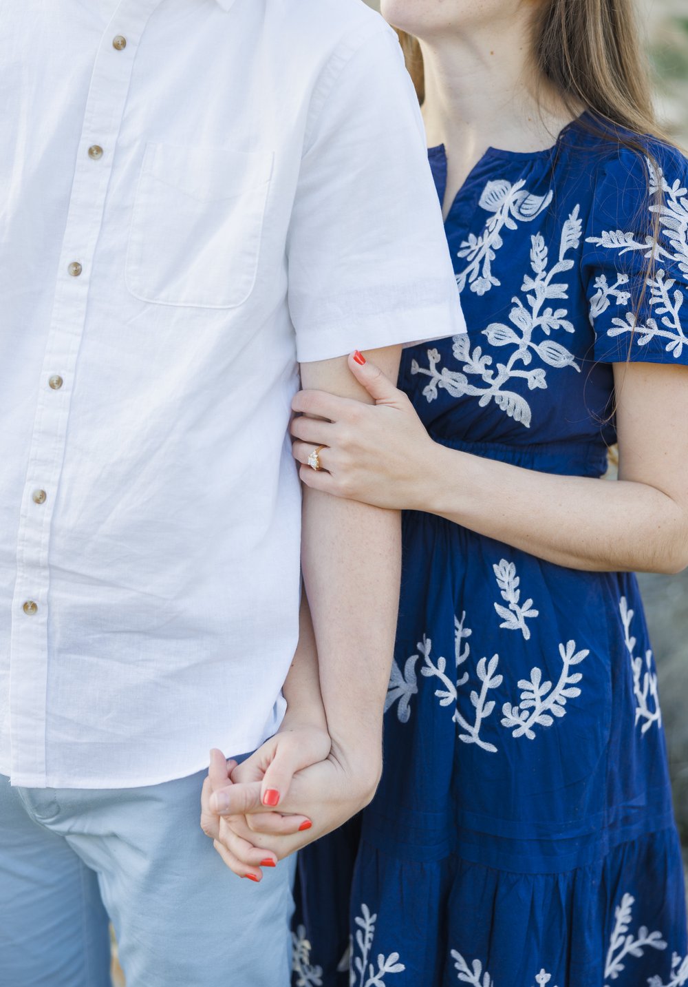  A detailed portrait of an engaged couple holding hands and standing close by Savanna Richardson Photography. blue dress engagements holding hands pink nails #SavannaRichardsonPhotography #SavannaRichardsonEngagements #UtahEngagements #AntelopeIsland