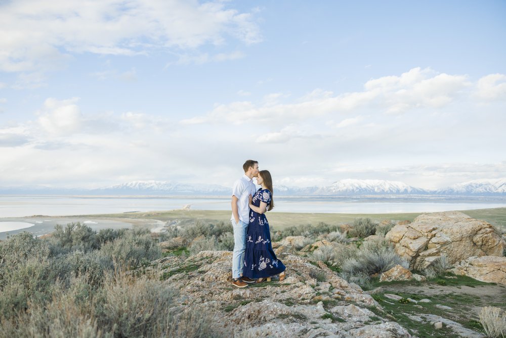  Stunning engagement photography with a couple standing on a mountain on Antelope Island in Utah by Savanna Richardson Photography. scenic engagement photography breathtaking views #SavannaRichardsonPhotography #SavannaRichardsonEngagements #UtahEnga