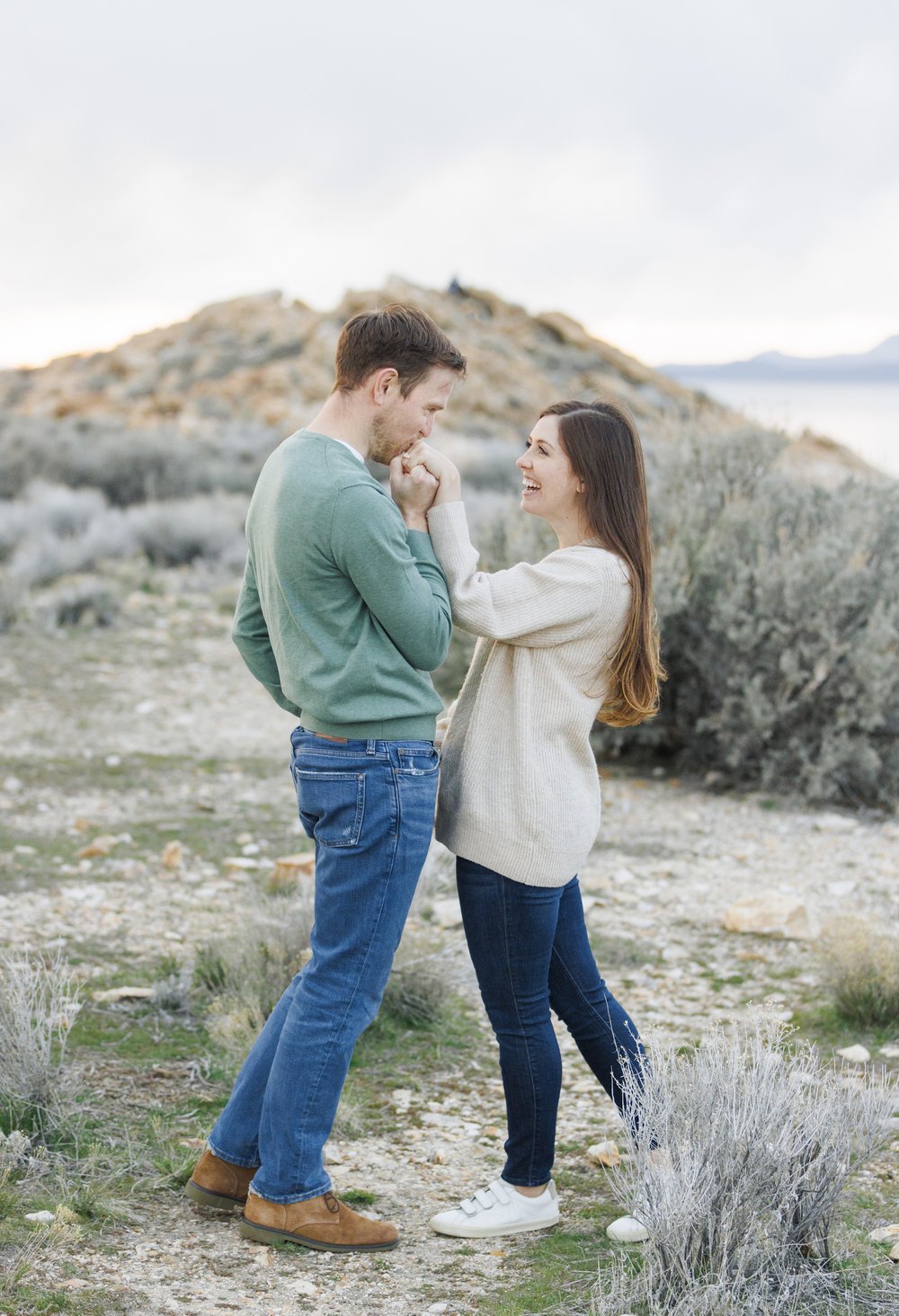  A man grabs his girlfriend's hand and kisses it on a mountain path in Utah by Savanna Richardson Photography. kissing her hand in love photography #SavannaRichardsonPhotography #SavannaRichardsonEngagements #UtahEngagements #AntelopeIsland #Springen