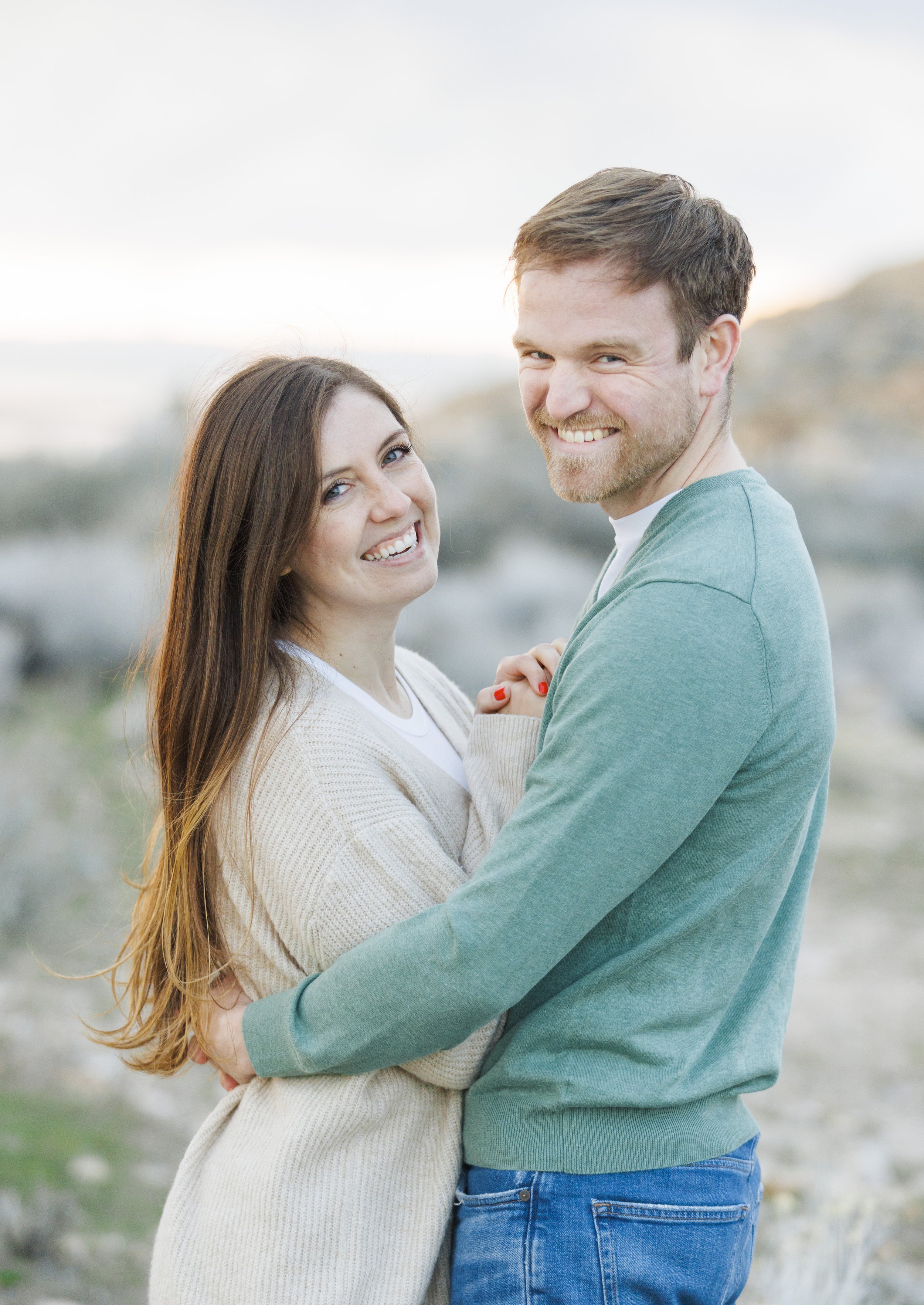  A man holds his fiance in a hug during a Spring engagement photography session with Savanna Richardson Photography. man holds woman in his arms snuggling #SavannaRichardsonPhotography #SavannaRichardsonEngagements #UtahEngagements #AntelopeIsland #S