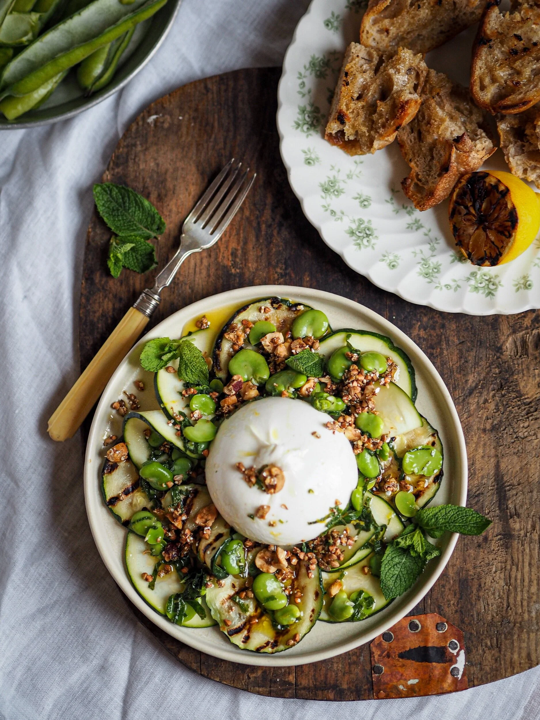 Burrata with grilled and raw courgette, broad beans, burnt lemon vinaigrette and buckwheat dukkah