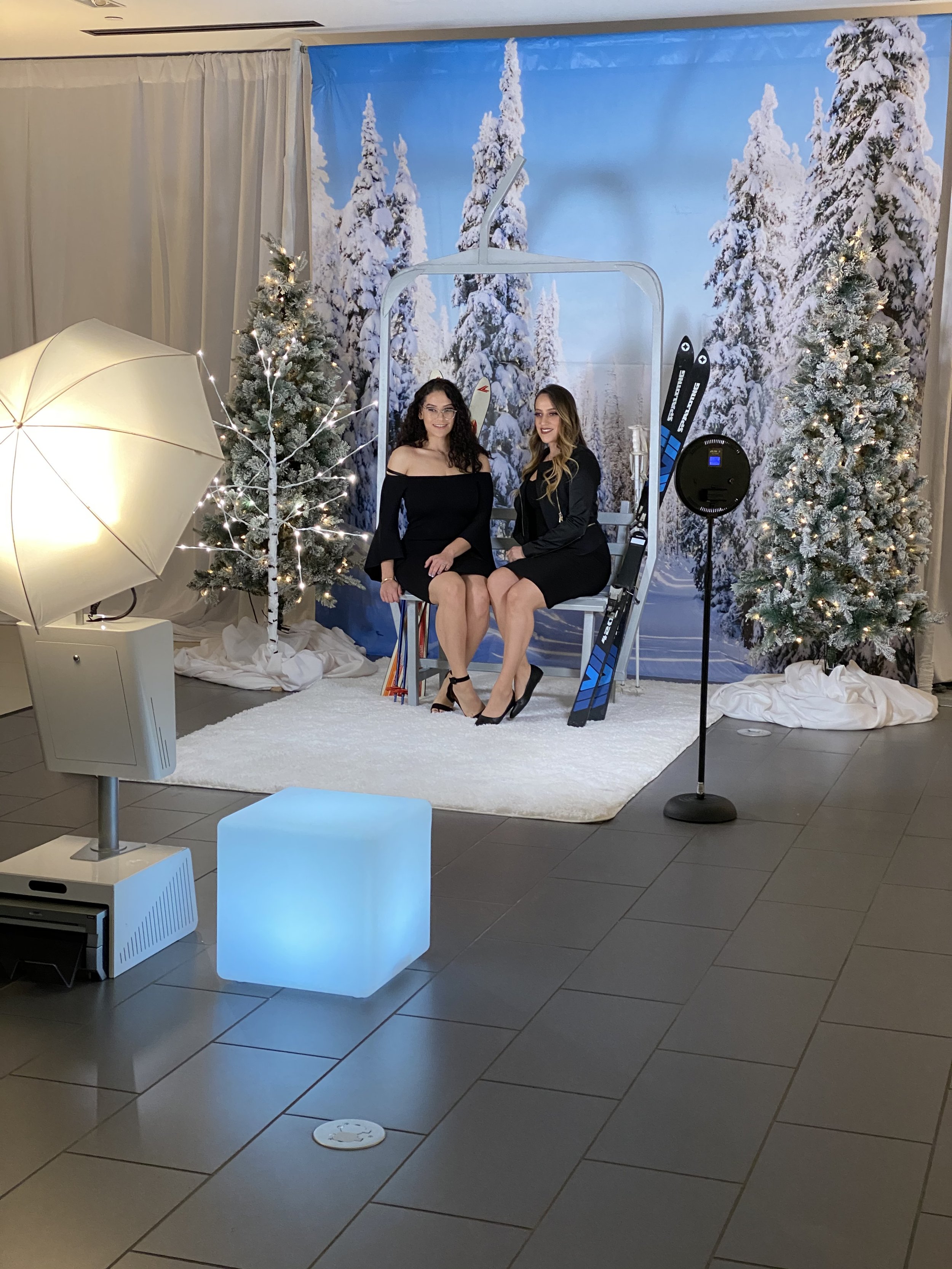 Guests using open-air photo booth with winter-themed backdrop and modern studio lighting setup during luxury corporate holiday event in Texas