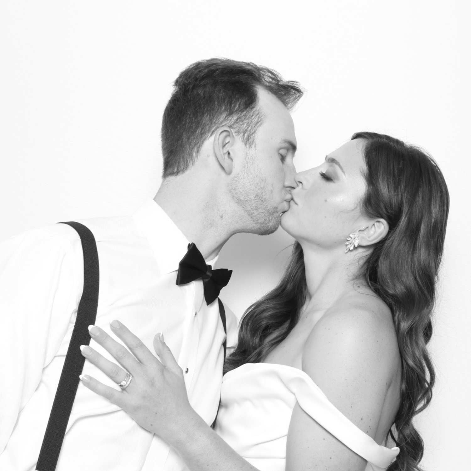 Black and white glam booth portrait of a couple kissing during a luxury wedding reception in San Antonio, featuring studio-style lighting and timeless editorial-inspired photography.