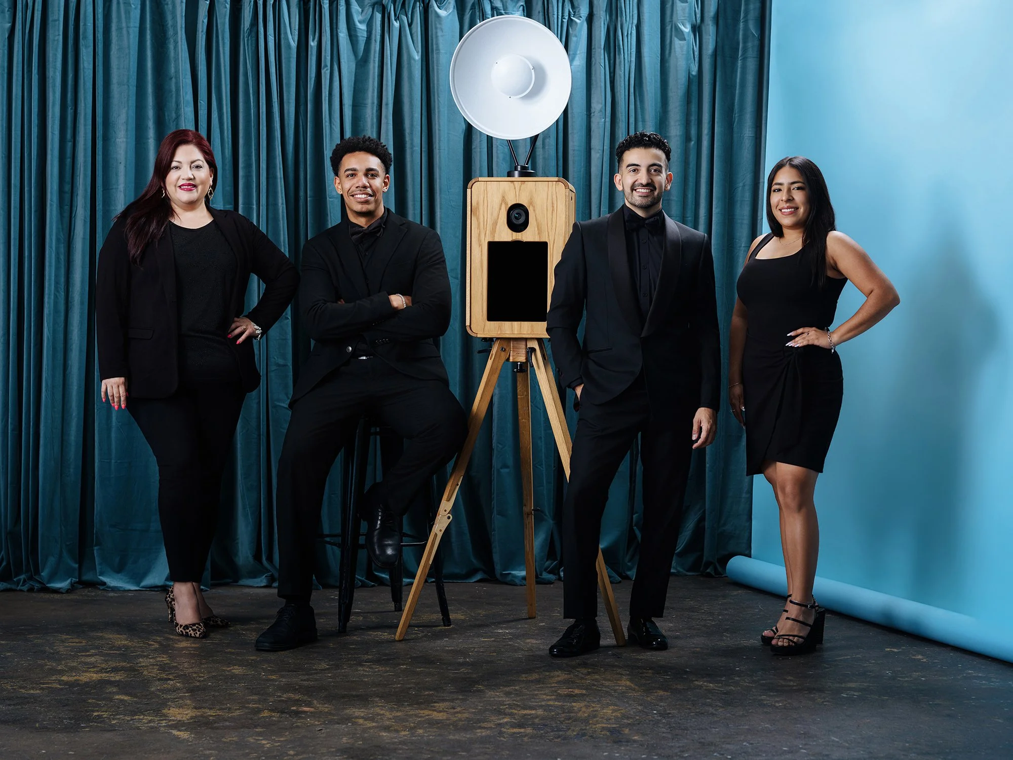 MBP Photo Booth team posing in front of blue luxury event backdrop during branded celebration and experiential activation