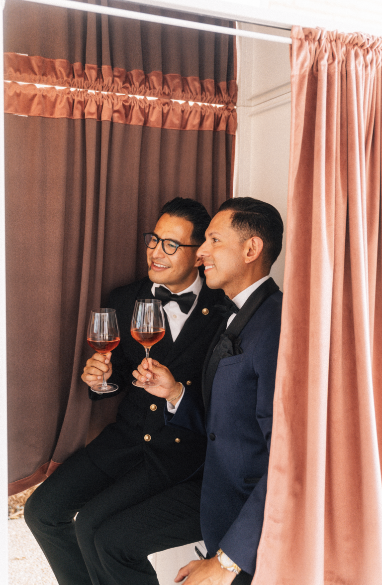 Wedding guests posing inside luxury enclosed photo booth with custom photo strip experience during upscale San Antonio reception