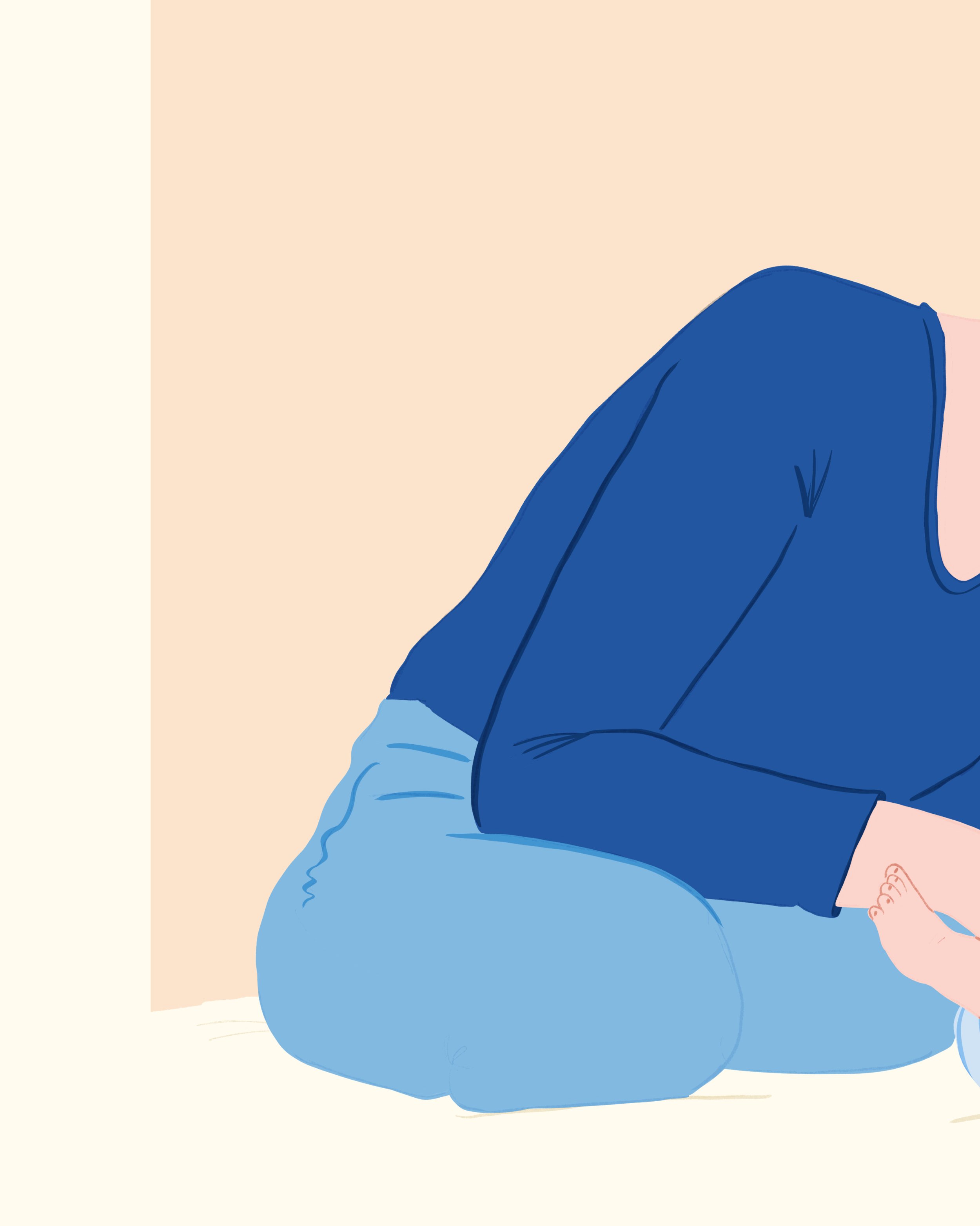 Une personne adulte assise avec les jambes pliées, portant un sweat-shirt bleu et un pantalon bleu.