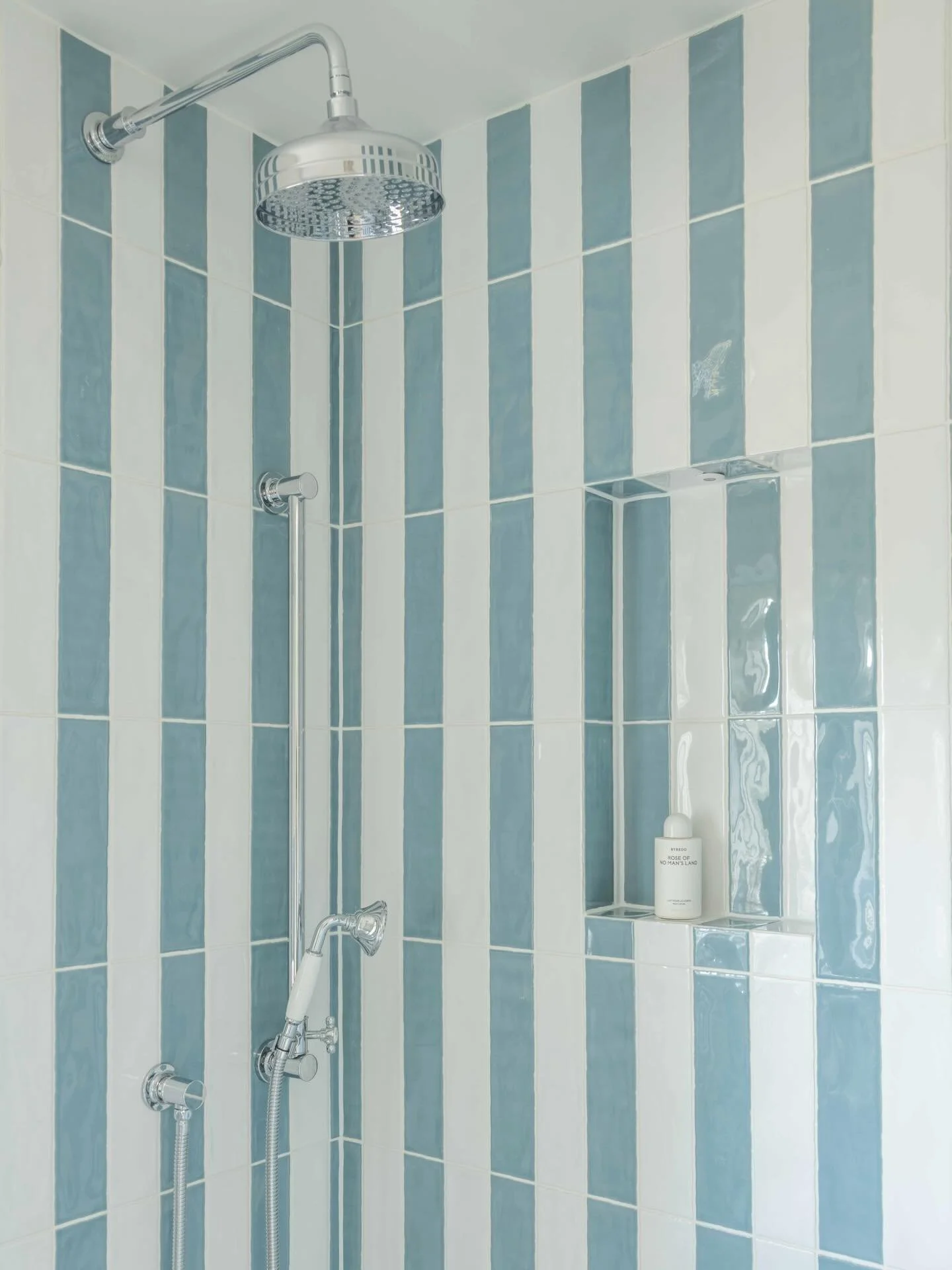 A considered approach to everyday spaces.
⠀⠀⠀⠀⠀⠀⠀⠀⠀
This shower design explores the balance between structure and softness&mdash;vertical striped tiling in muted blue and white elongates the space, while introducing a calm, rhythmic visual language. 