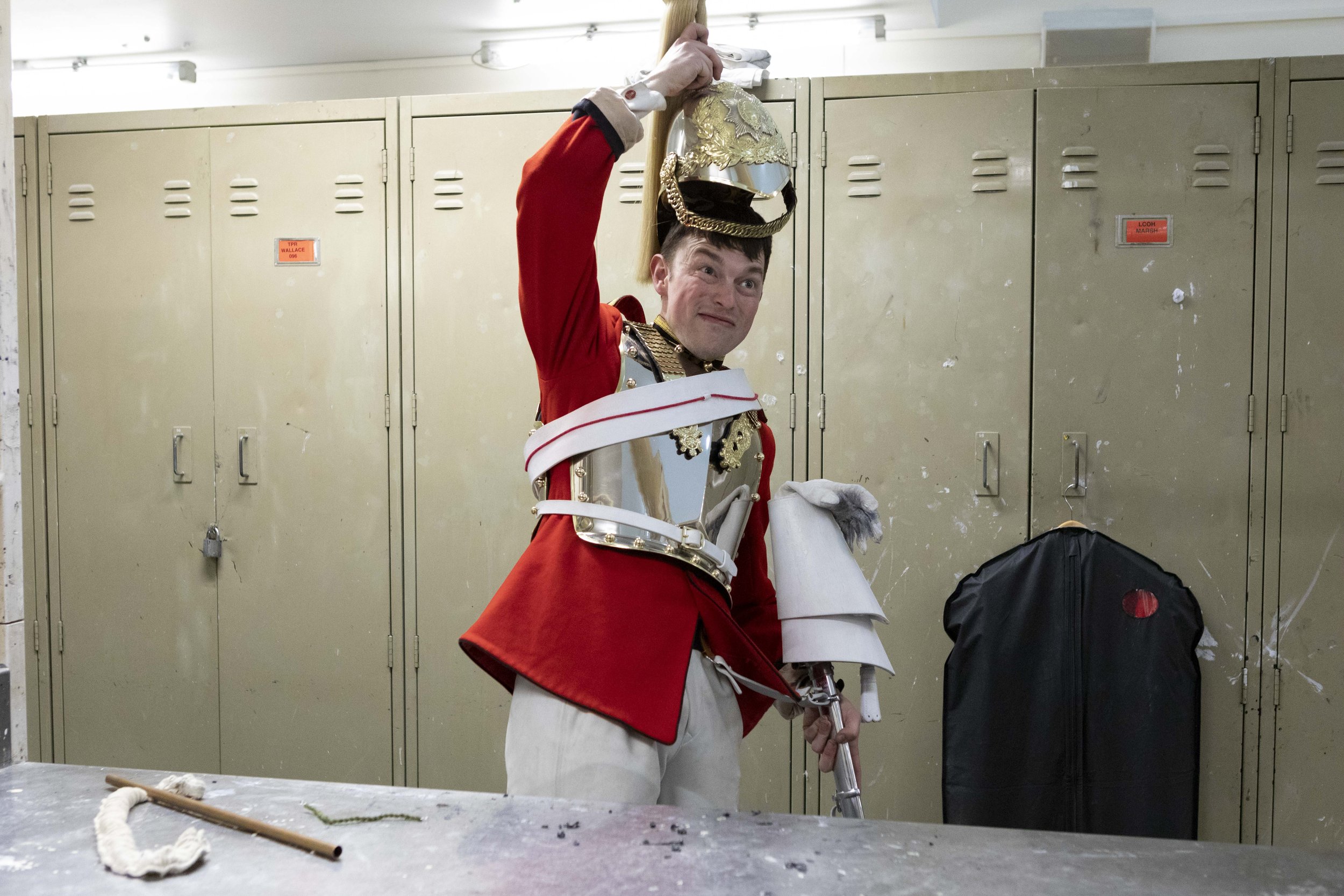  A Life Guard of the Household Cavalry Mounted Regiment (HCMR) puts on his helmet ahead of a Trooping the Colour rehearsal - May 2022. 