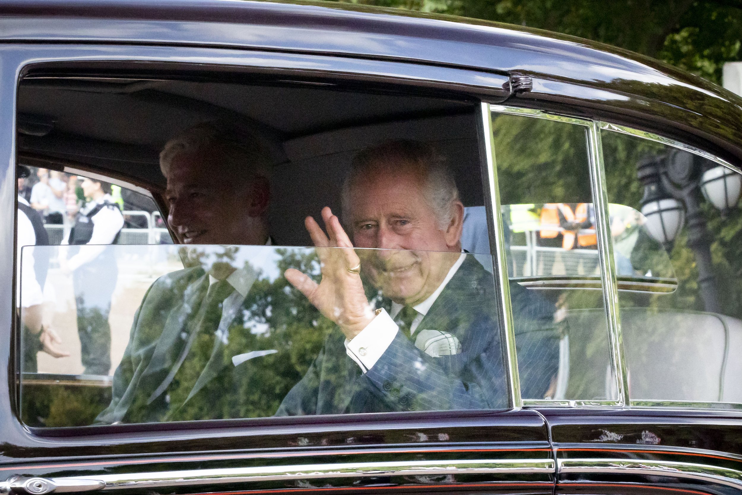  King Charles III waves to fans as he returns to Buckingham Palace ahead of meeting political leaders - Sept 2022.  
