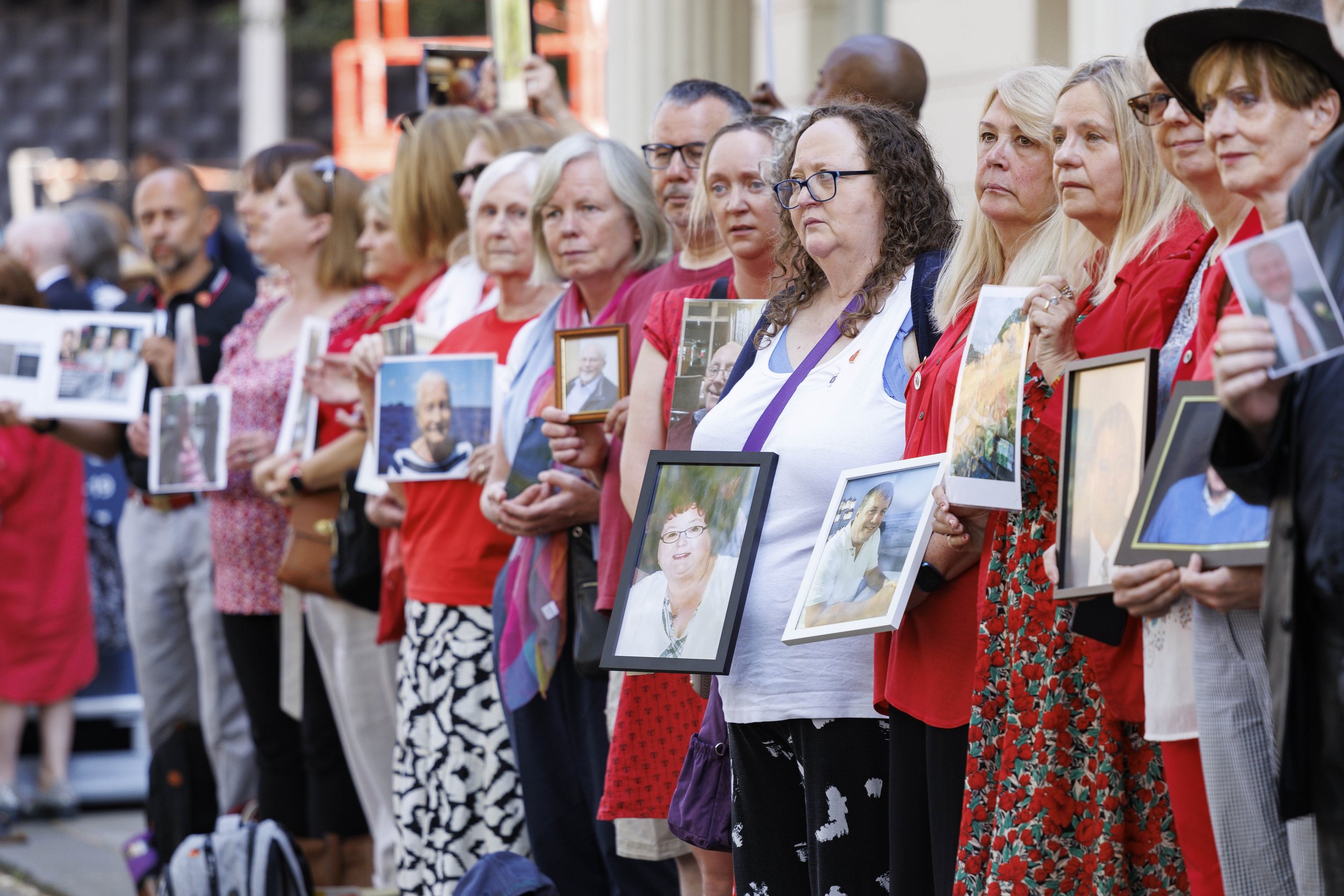  Bereaved relatives hold pictures of loved ones who died of Covid at the Covid-19 Inquiry - Jun 2023. 