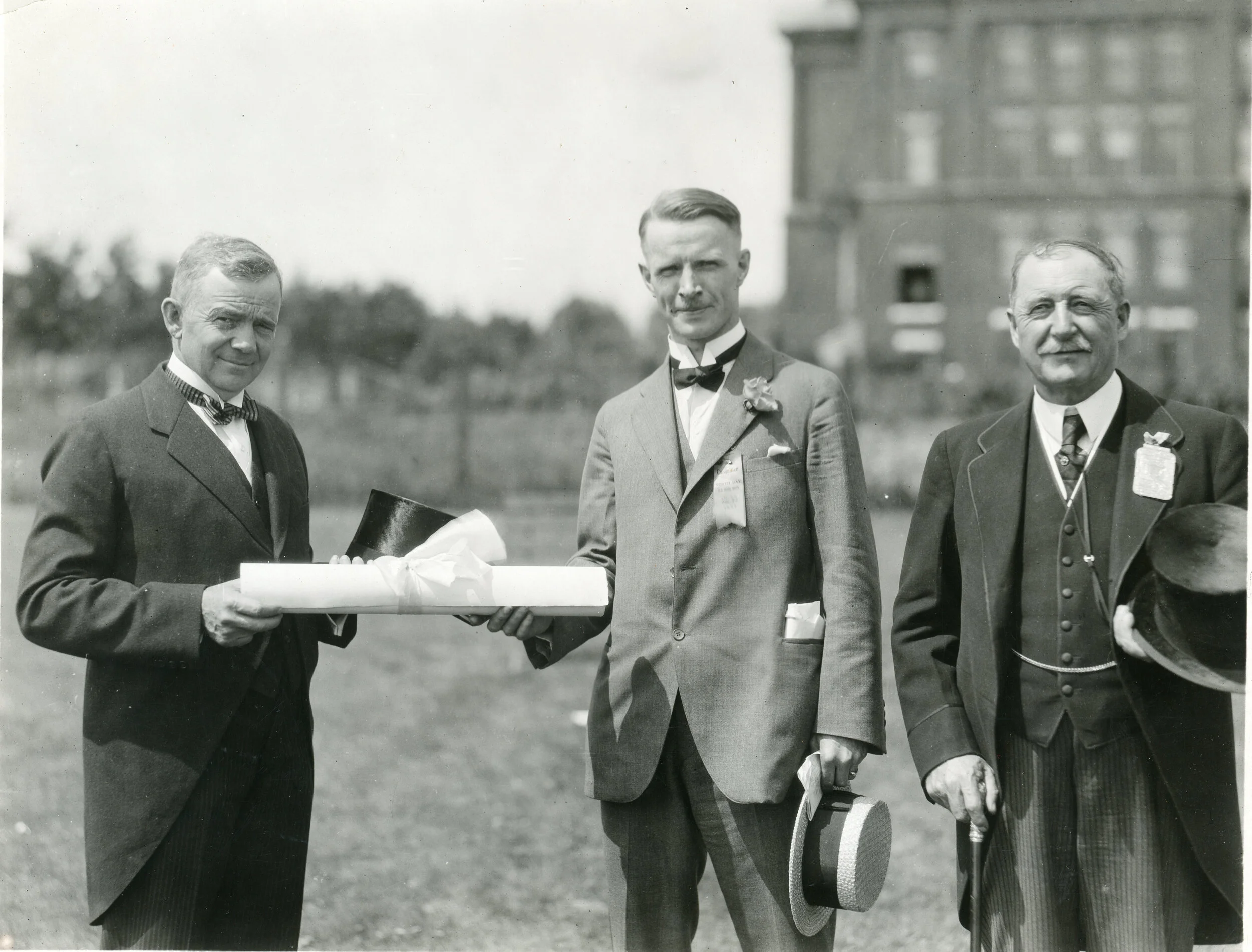 The Honourable Charles Crea, Minister of Mines, presented the charter to City Mayor McDonald and Mr. John Ferguson who was president of the Old Home Week Association.