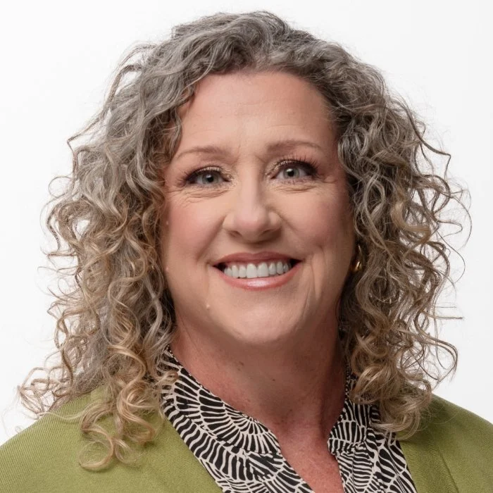 Woman with glasses smiling indoors