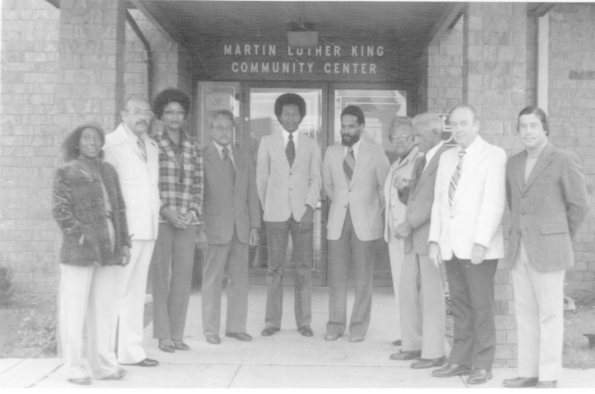 A group of ten people standing in front of the Martin Luther King Community Center entrance.