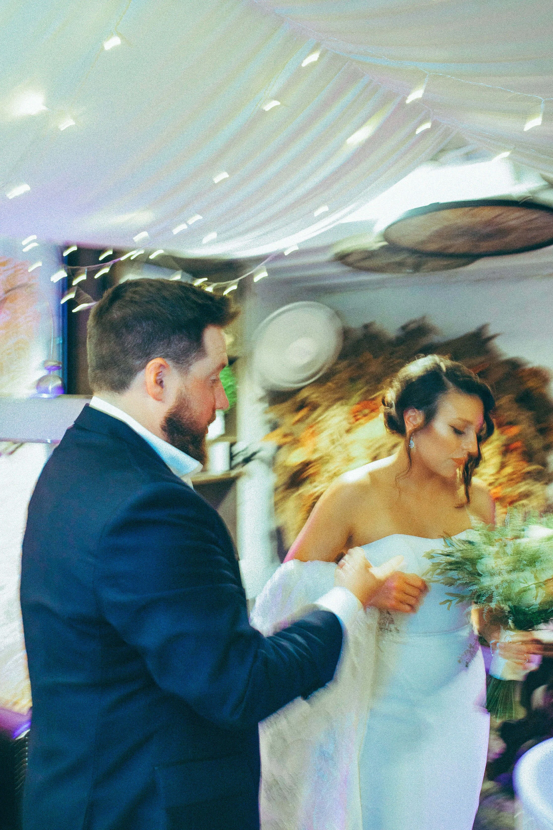 a bride and groom in motion, bright blues, yellows and oranges paint a slightly blurred emotive picture