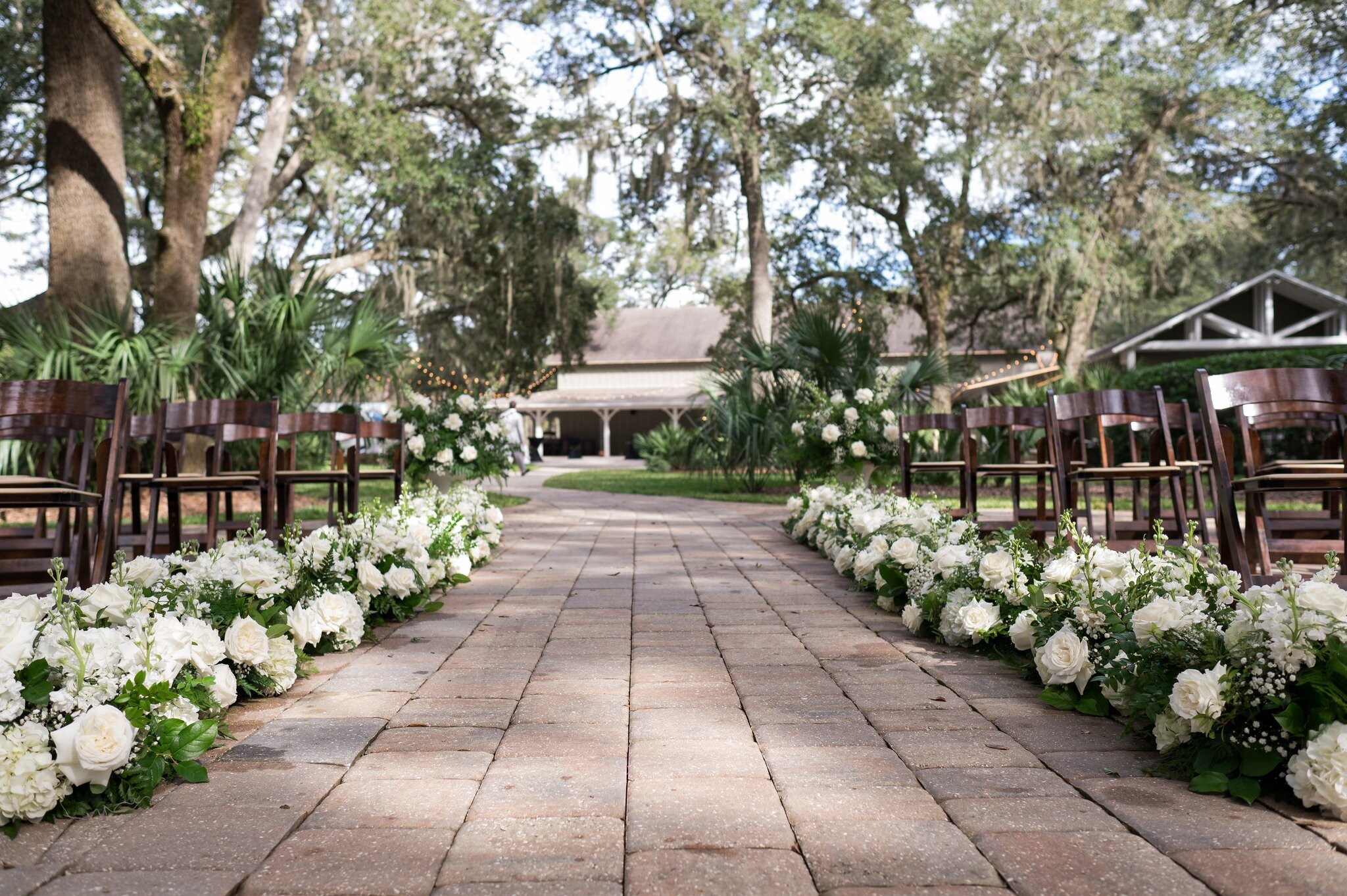 We love this unique view of our &quot;I Do&quot; Oak ceremony area! The flowers lining the aisle are simply stunning.

@afantasyinflowers
@southerncharmevents
@bethanywalterphoto
@footloosedjs
@4riverscatering
@stjohnsilluminations

#weddingday #wedd