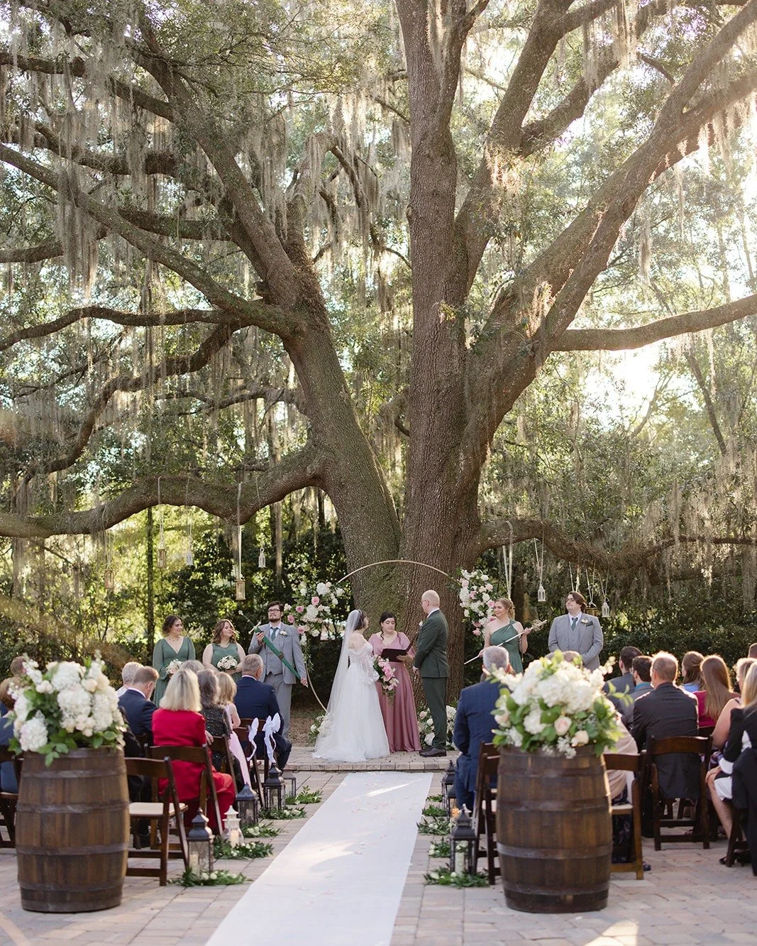 This fairytale garden wedding at Bowing Oaks came to life with soft pastel florals, glowing lanterns, and a setting that felt quietly enchanting beneath the oaks. Every detail was layered with intention, creating an atmosphere that felt romantic, whi