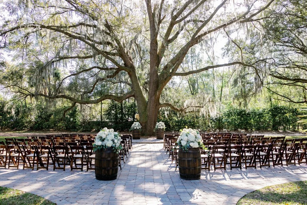 The moment everything begins.

Guests take their seats, sunlight filters through the Spanish moss, and all eyes turn toward the aisle. Beneath the branches of the I Do Oak, couples exchange vows in a setting that feels both grand and deeply personal.