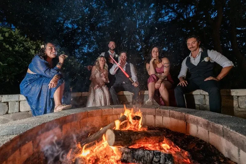 Not your average wedding night. 🔥✨

Cigars around the fire pit, good friends, plenty of laughs... and apparently, a lightsaber.

Some of the best wedding memories happen after the formalities are over and everyone can simply relax and have fun. The 