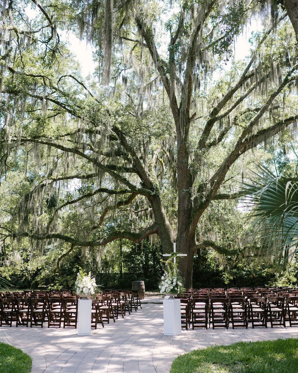 When your ceremony backdrop looks like this, you don&rsquo;t need much else. 🌿🤍

A simple white cross, two floral arrangements, and classic white columns were all this couple needed to create a beautiful focal point beneath the oak trees at Bowing 