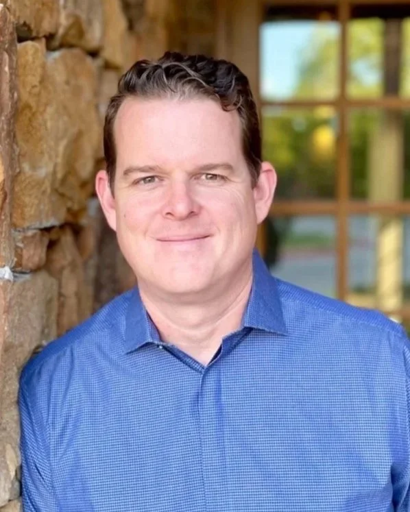 Zack Durham, couples & family therapist standing in front of office building of Harvest Counseling & Wellness in Argyle, TX. Zack specializes in anxiety/depression, TBIs, Stroke Recovery, Parenting & Family Issues, & Men's issues.