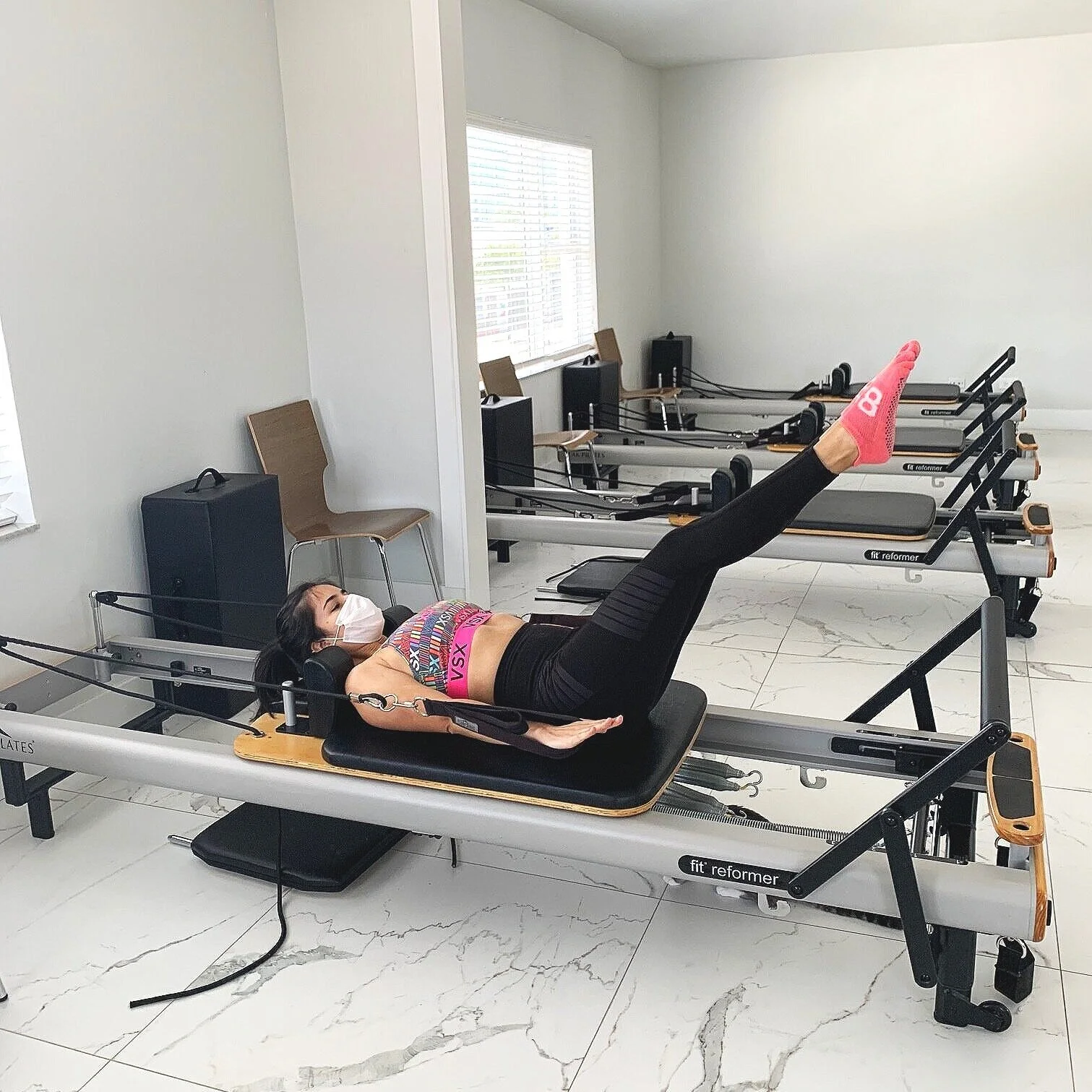 Client performing a Pilates exercise on the reformer at Renegade Pilates in Miami