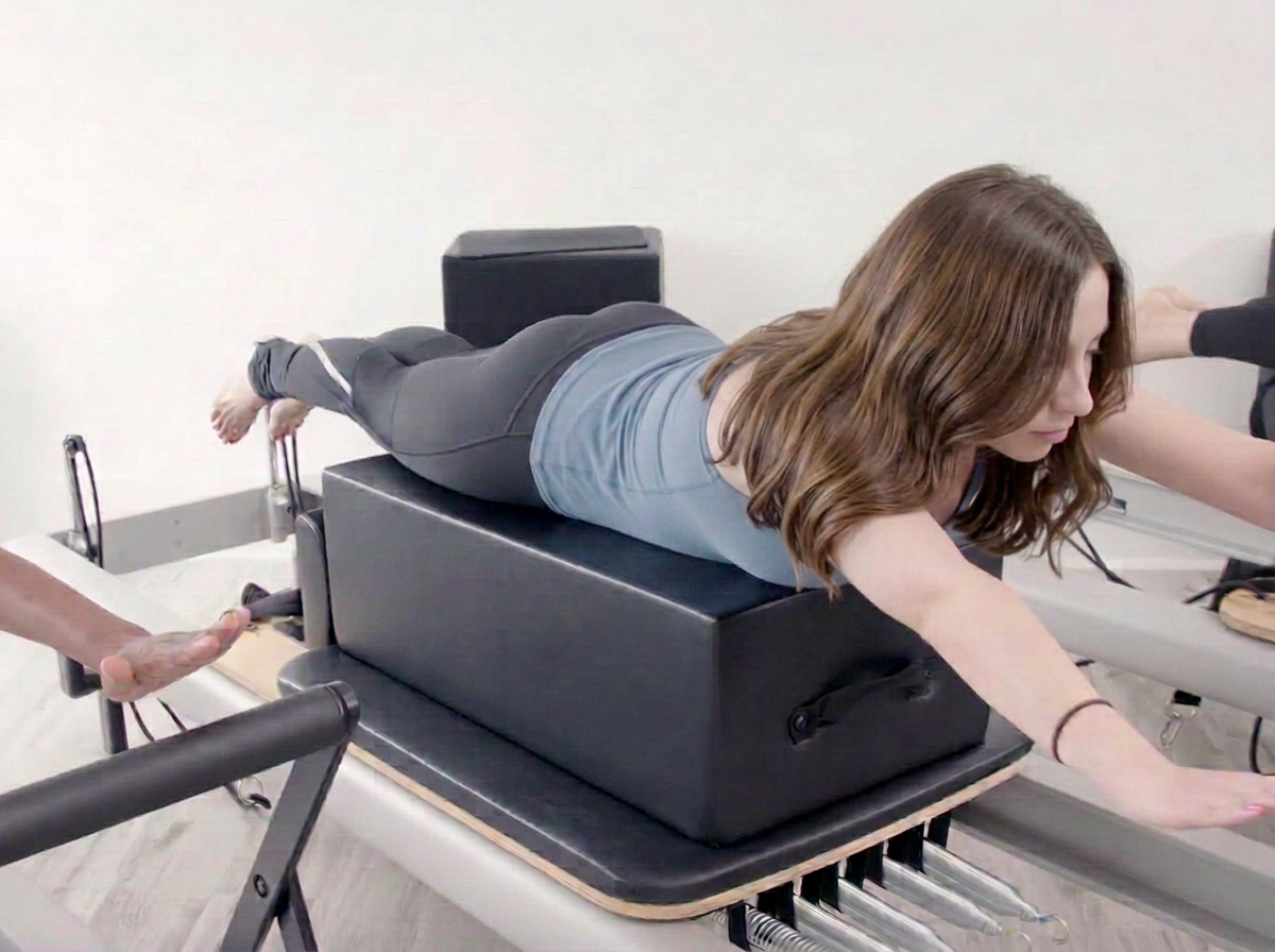 Woman practicing Reformer Pilates at Renegade Pilates in Miami