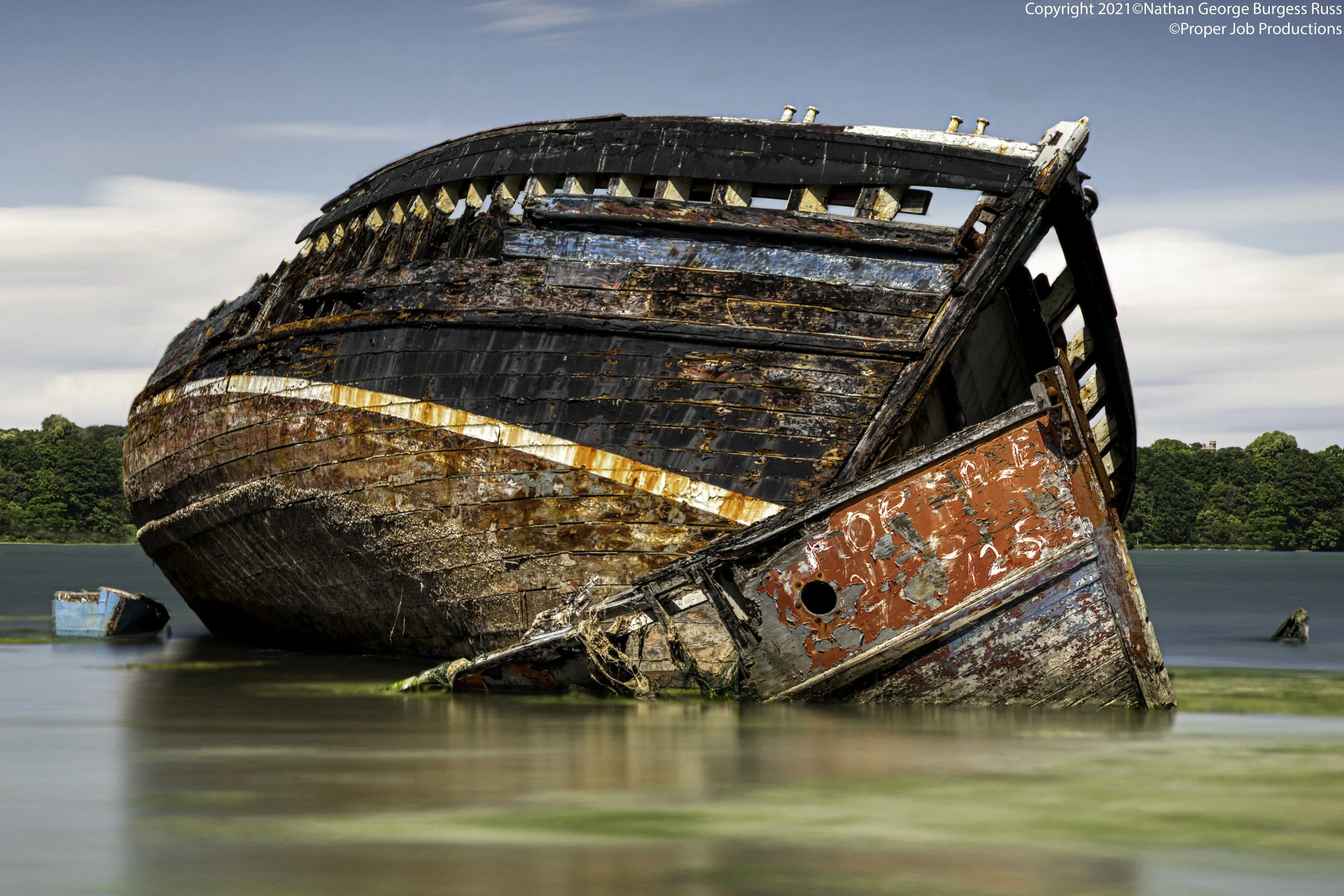 Three wooden hulled boats in various states of decay in the Pin Mill Boatyard Graveyard. Pin Mill a hamlet situated on the banks of the River Orwell, Suffolk 