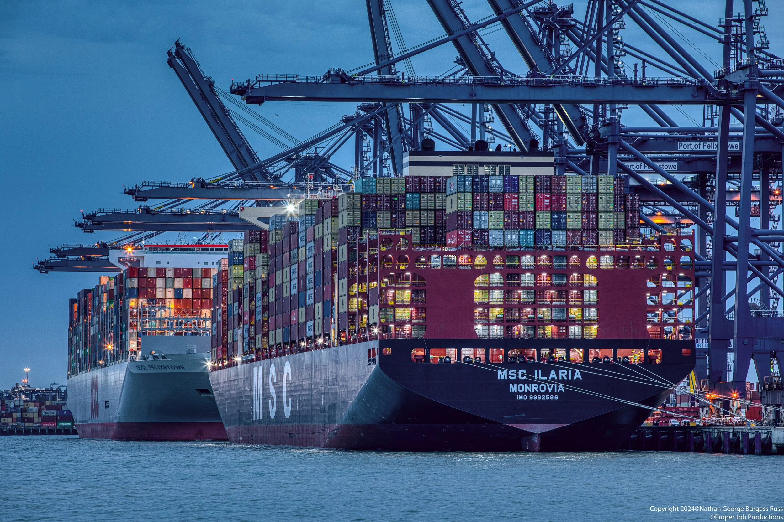 MSC Ilaria and OOCL Felixstowe in the Landguard terminal in the Port of Felixstowe during blue hour.