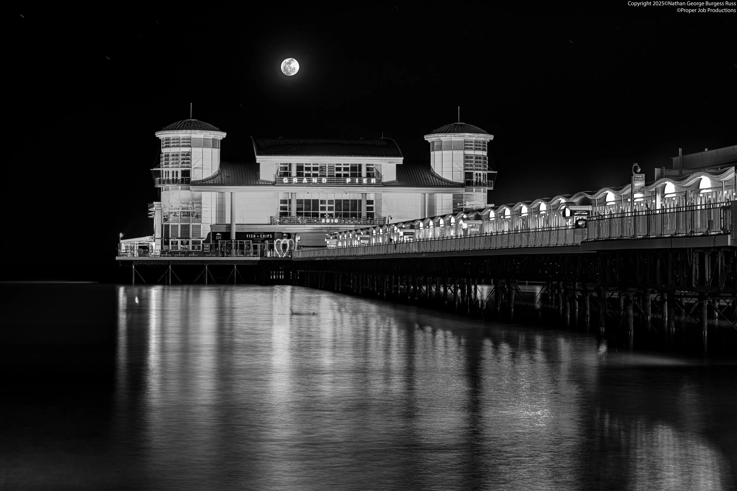 Weston-Super-Mare Grand Pier at night during a Spring High Tide with the full moon up.