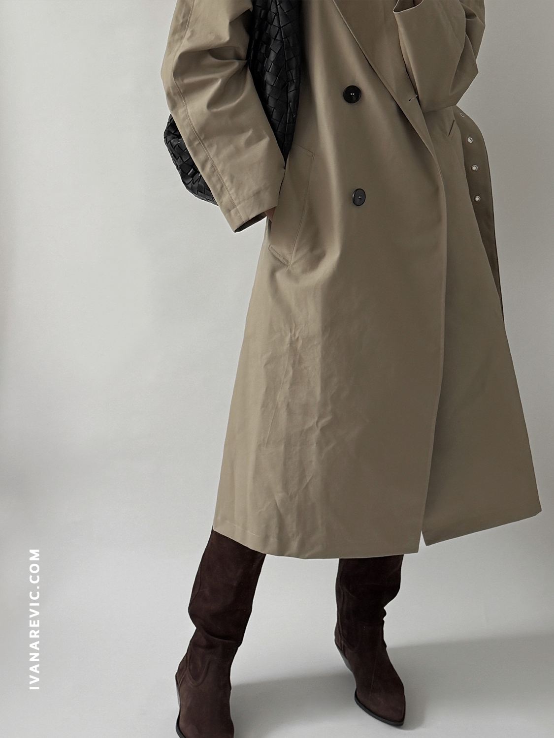 Ivana Revic in Zara belted cotton trench coat, Zara brown suede cowboy boots, and Bottega Veneta large black Jodie leather woven bag